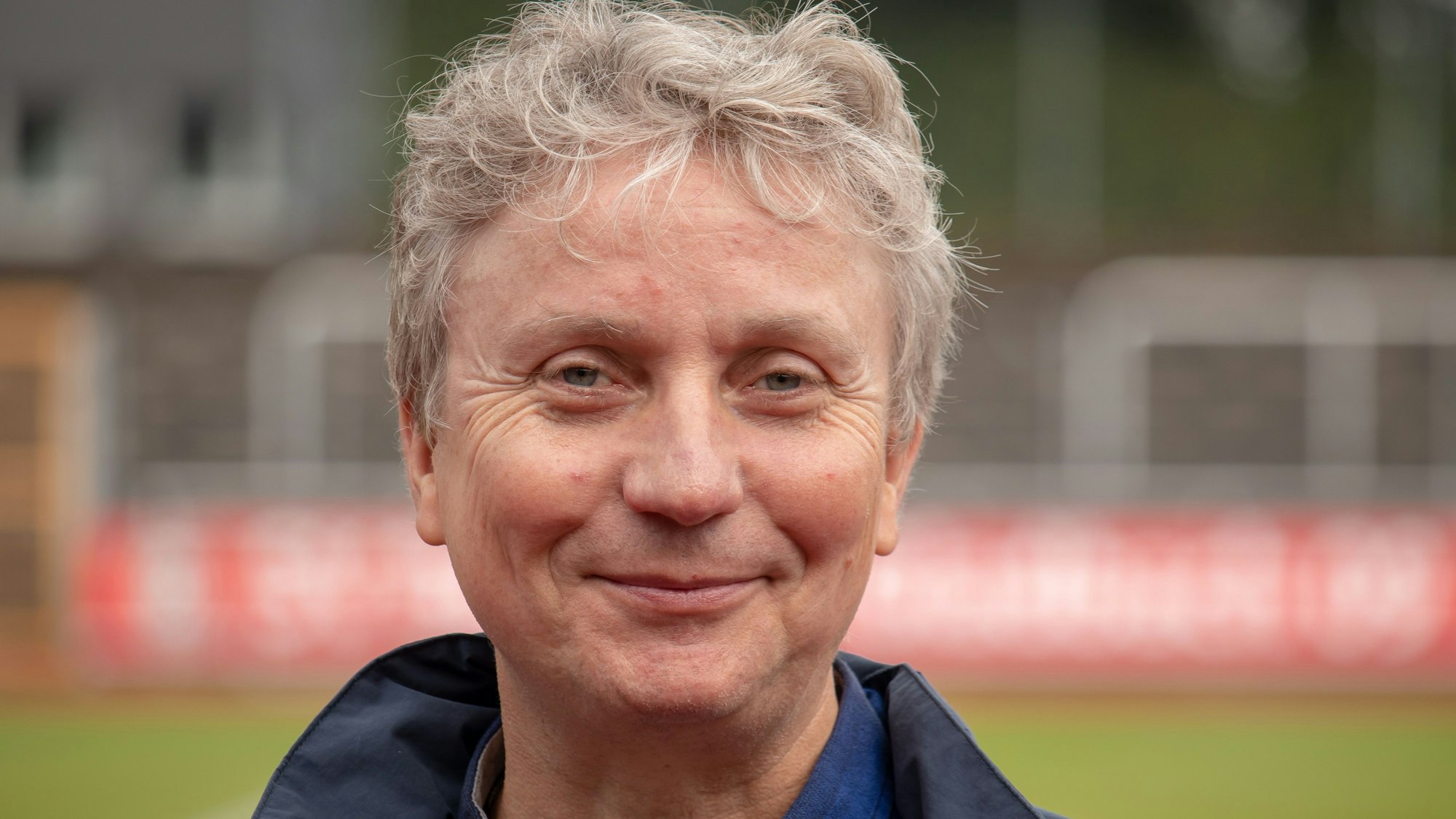 Jürgen Langenbucher aus Leichlingen steht auf einem Fußballplatz und schaut in die Kamera.
