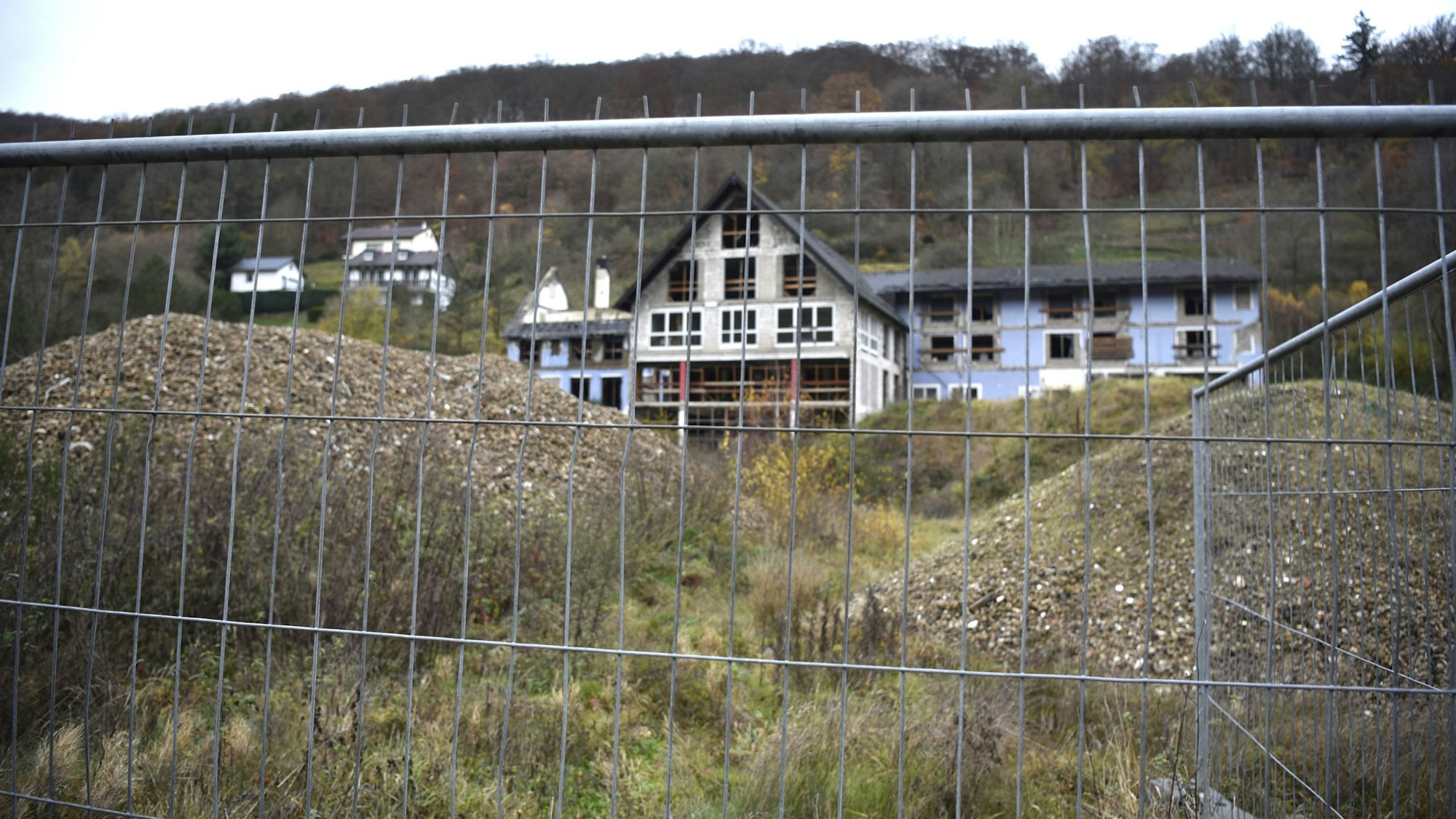 Die Eifelsteig Lodge in Erkensruhr ist nur eine Ruine - Blick durch einen Bauzaun auf das ehemalige Hotel.