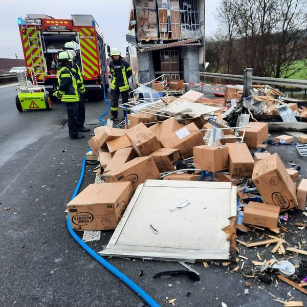 Kartons liegen auf der Autobahn, die Feuerwehr ist vor Ort.