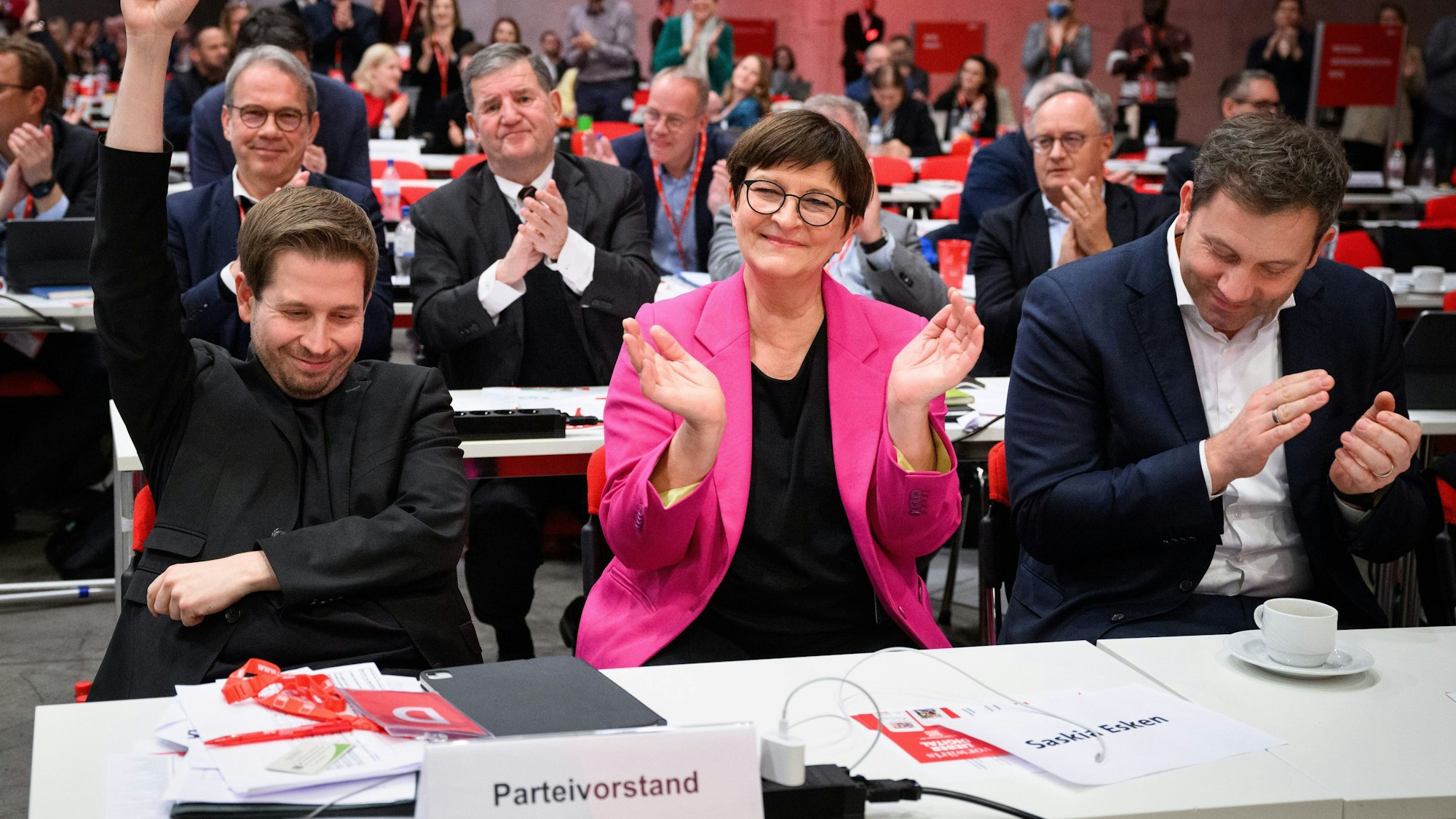 Kevin Kühnert (l-r), SPD-Generalsekretär, Saskia Esken, Vorsitzende der SPD, und Lars Klingbeil, Vorsitzender der SPD, reagieren beim ordentlichen Bundesparteitag der SPD auf dem Berliner Messegelände auf das Wahlergebnis zur Wiederwahl von Kevin Kühnert als Generalsekretär der SPD.