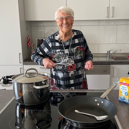 Eine alte Dame kocht und der Roboter Pepper unterstützt.