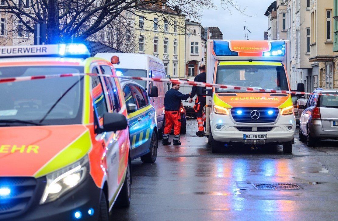 Krankenwagen und Polizei stehen auf der Strasse an einem Tatort.