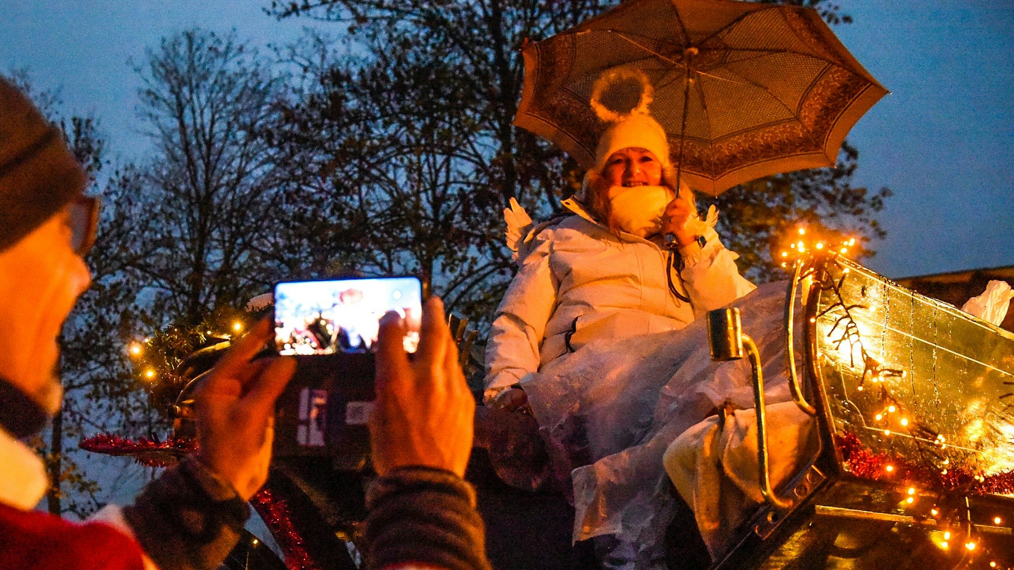 Eine Frau sitzt als Engel verkleidet auf einer Kutsche beim Lichterzug.