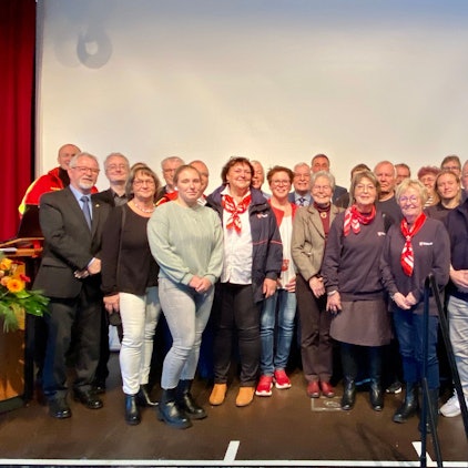 Männer und Frauen stehen auf einer Bühne.