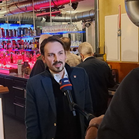 Matthias Großgarten steht an einem Mikrofon.