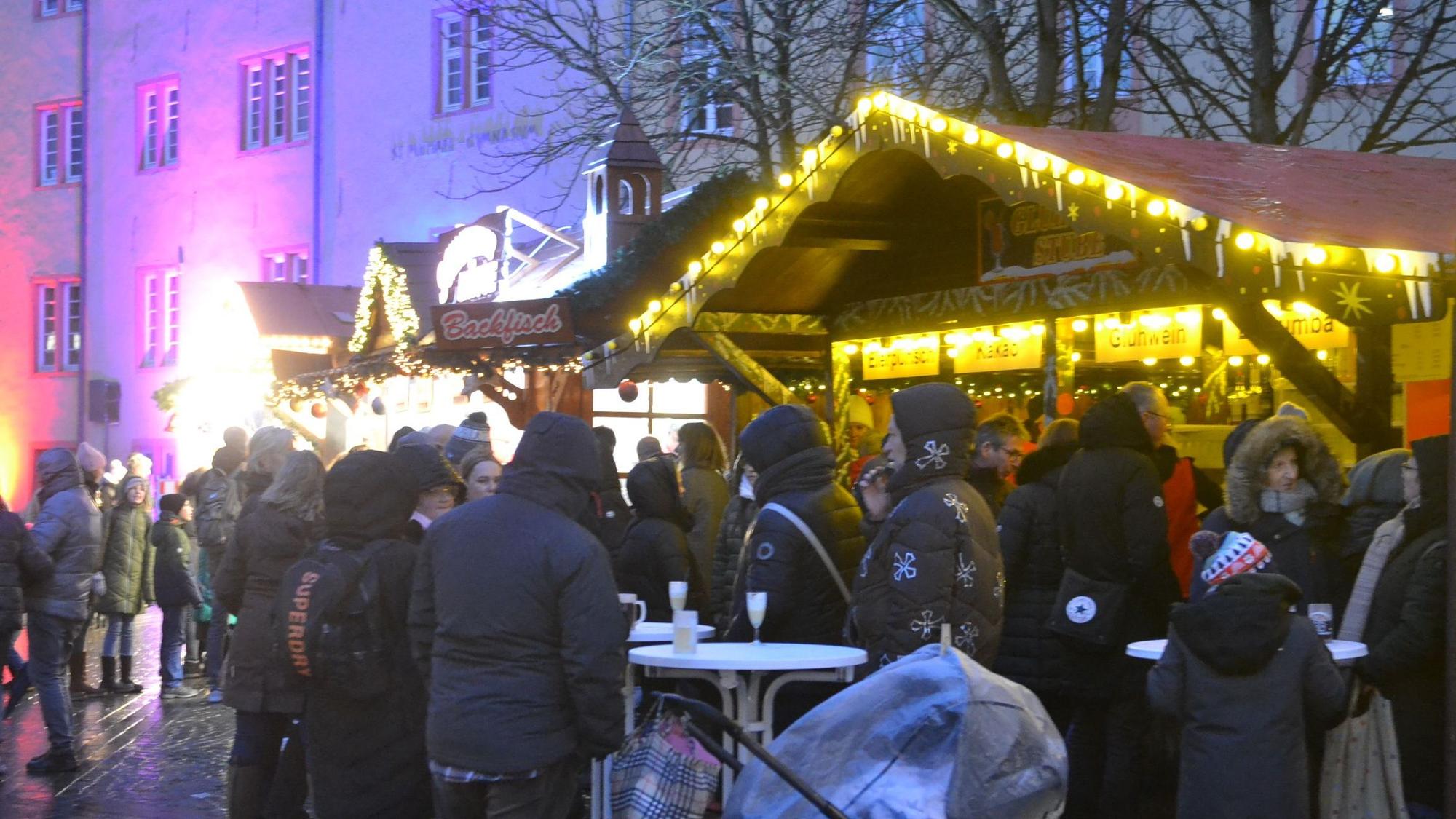 Menschen in dicken Jacken stehen an Weihnachtsmarkt in Bad Münstereifel