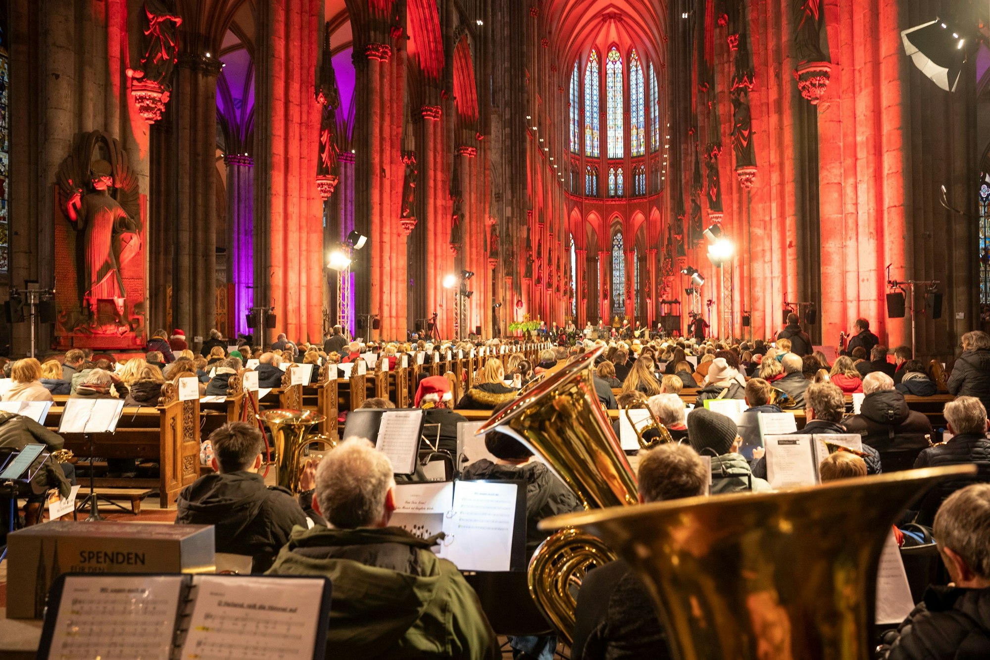 Blick von hinten auf die voll besetzten Bankreihen im Kölner Dom.