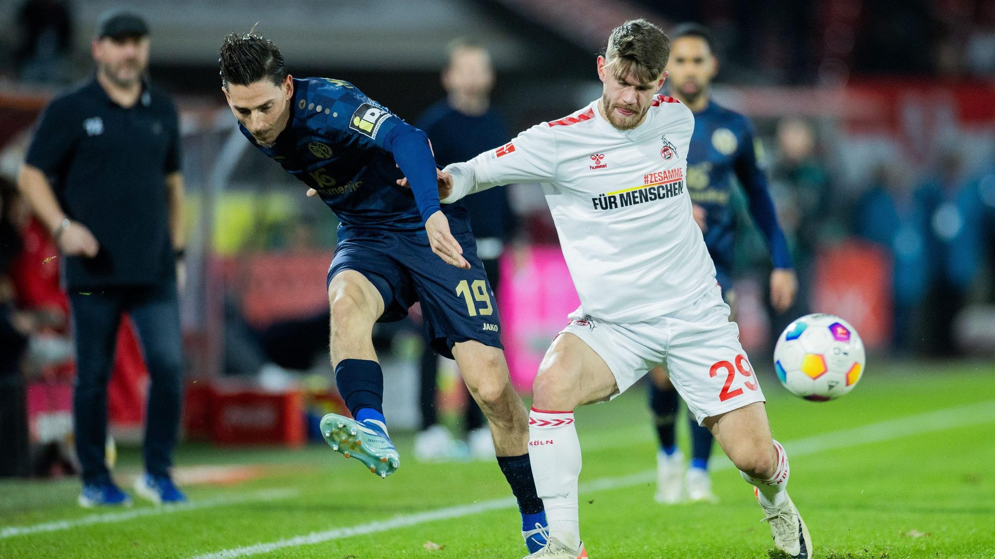 Kölns Jan Thielmann (r) und der Mainzer Anthony Caci versuchen an den Ball zu kommen.