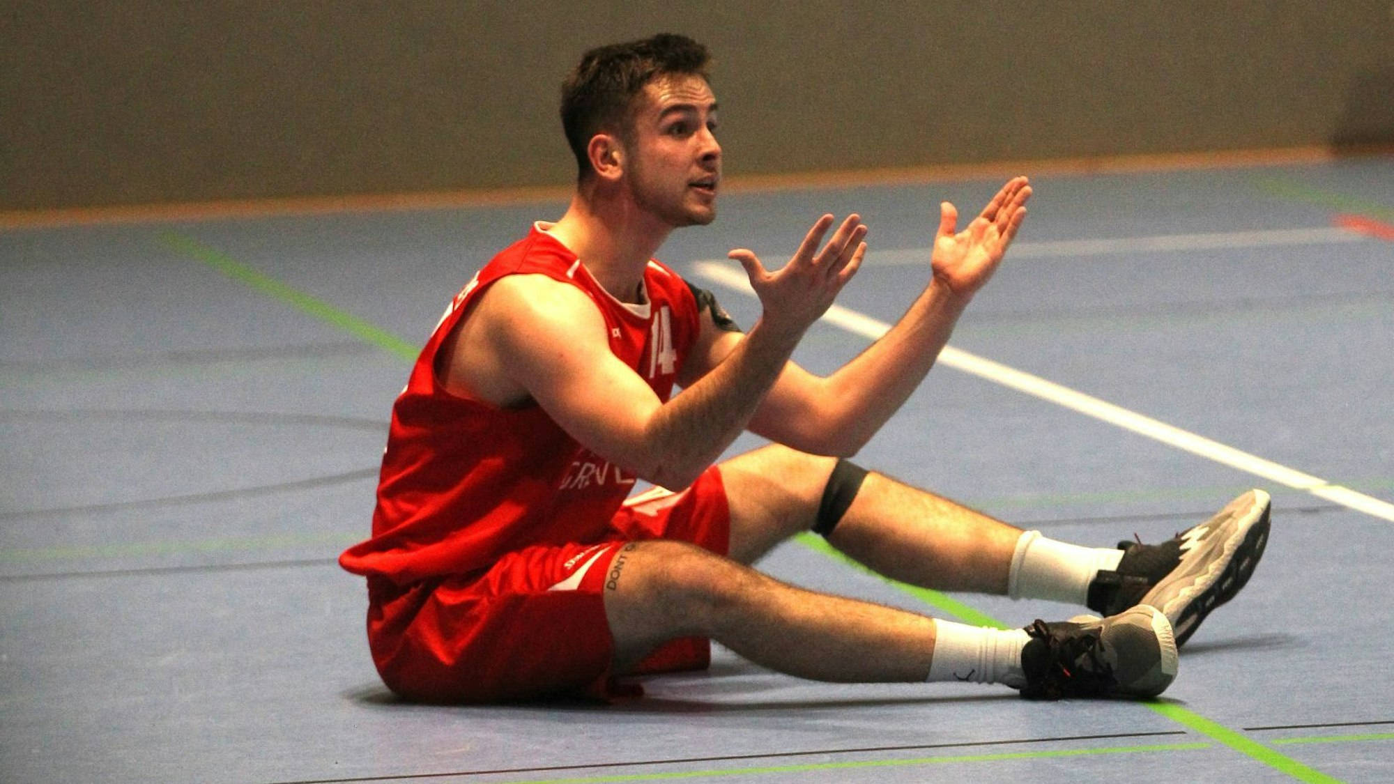 Chris Beier sitzt auf dem Boden und beschwert sich über eine Schiedsrichterentscheidung.