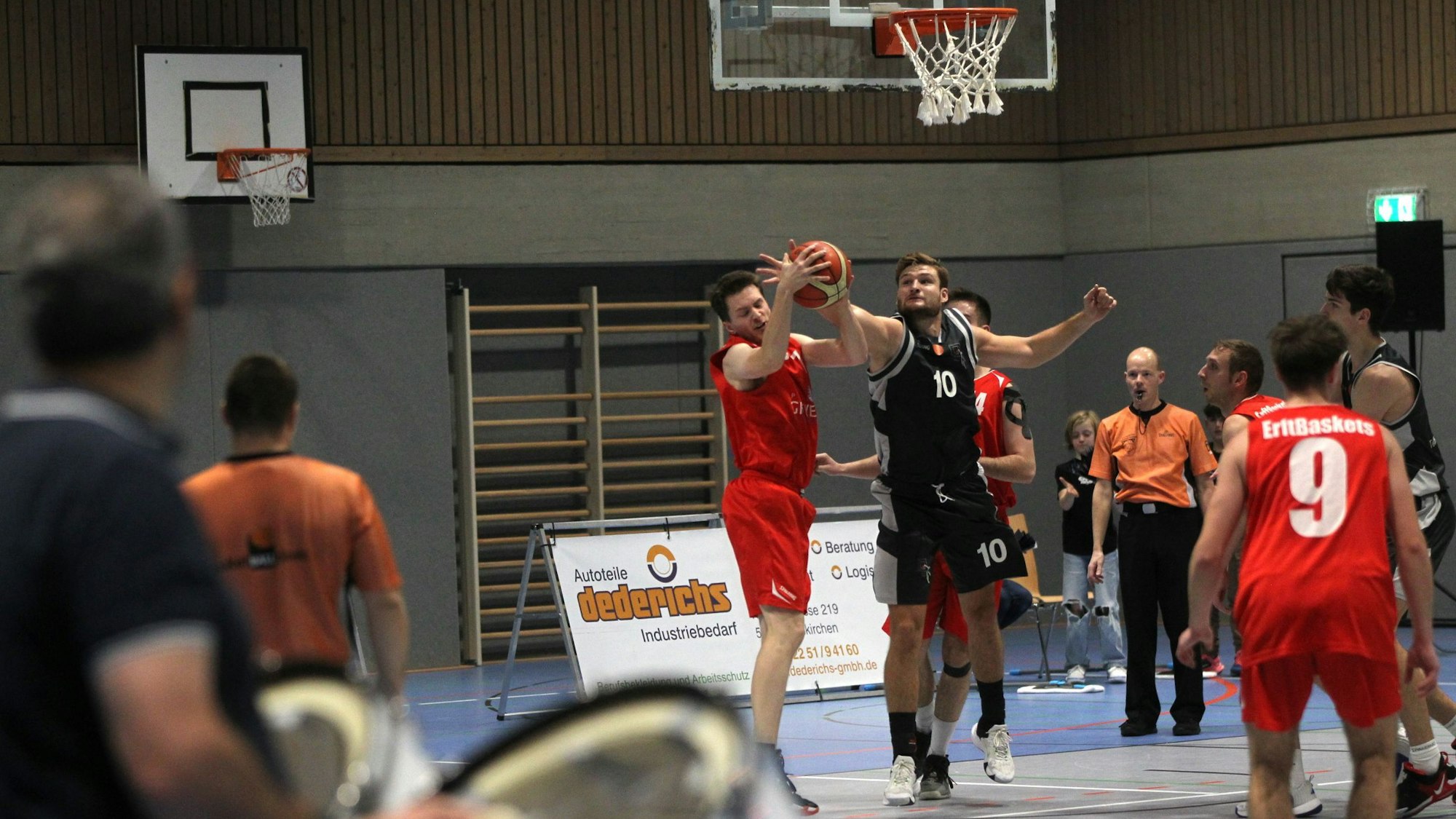 Matthias Zalfen blockt einen Ball. Im Vordergrund sind unscharf die Trommler der Erftbaskets zu erkennen.