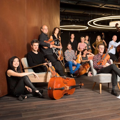 Die Musiker des Ensembles Resonanz posieren sitzend und stehend mit ihren Instrumenten im Resonanzraum St. Pauli.