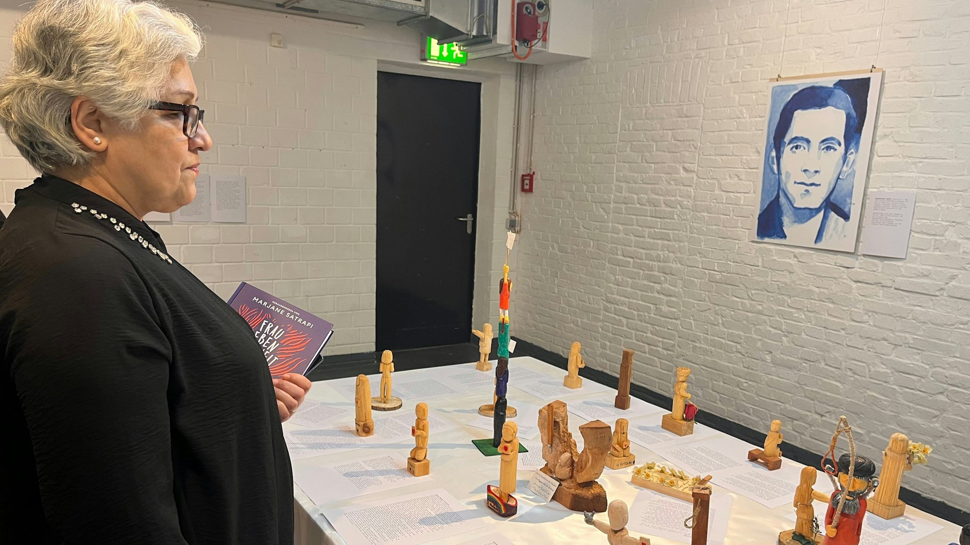 Man sieht die Holzfiguren von Shole Pakravan, deren Tochter im Iran hingerichtet wurde.