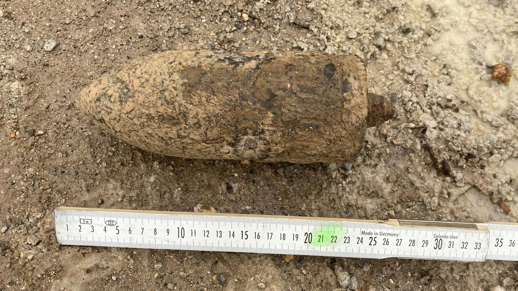 Eine Granate aus dem Zweiten Weltkrieg – zum Größenvergleich ist ein Zollstock zu sehen.