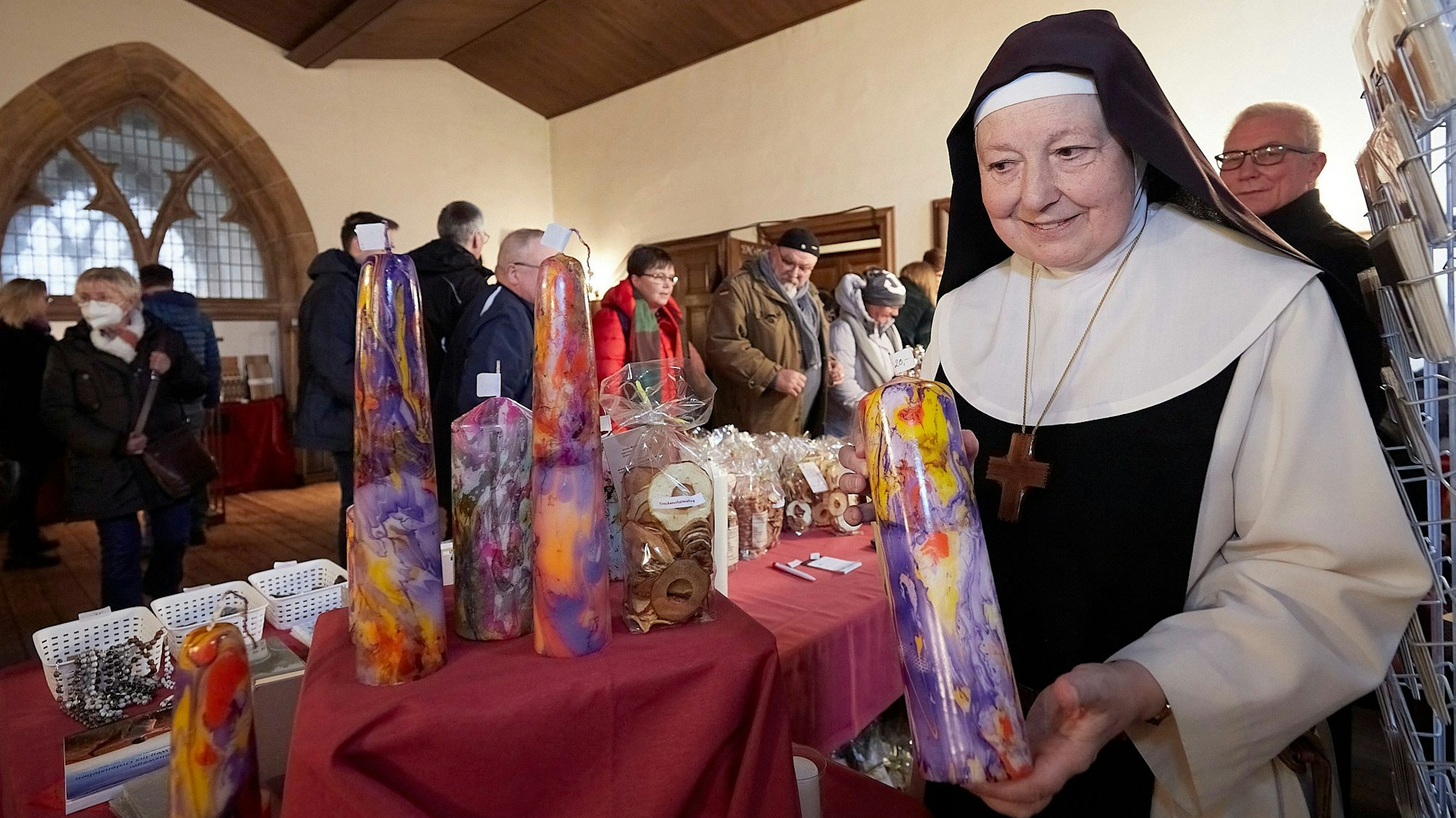 Sr. Gratia von den Trappistinnen zeigt ihre bunten selbst gemachten Kerzen.