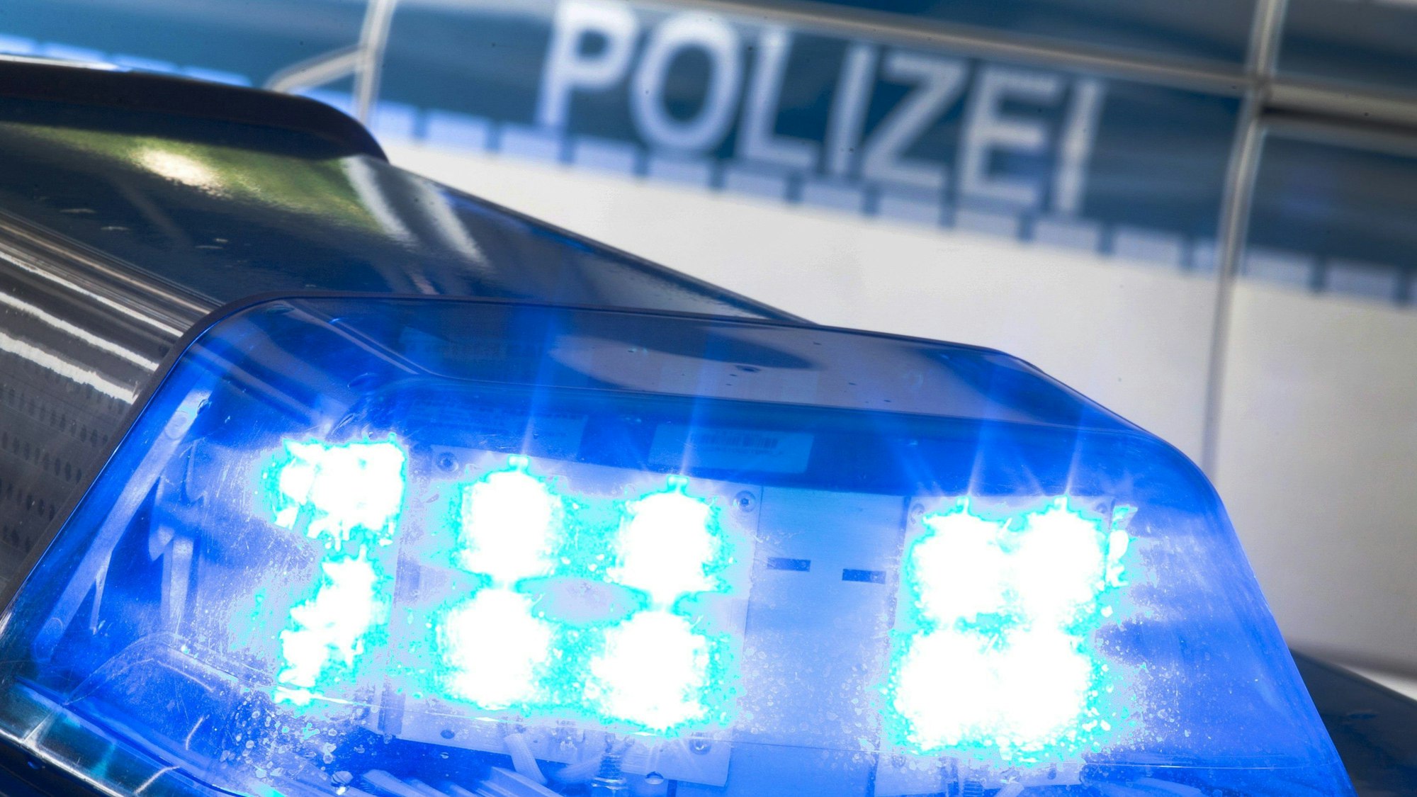 Das Blaulicht eines Polizeiwagens leuchtet.