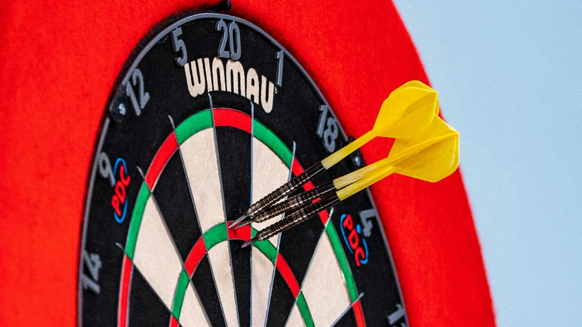 Drei Dartpfeile stecken in einer Dartscheibe. Am 6. April 2024 wird im „Gloria“ ein Darts-Turnier für den guten Zweck veranstaltet (Symbolbild)