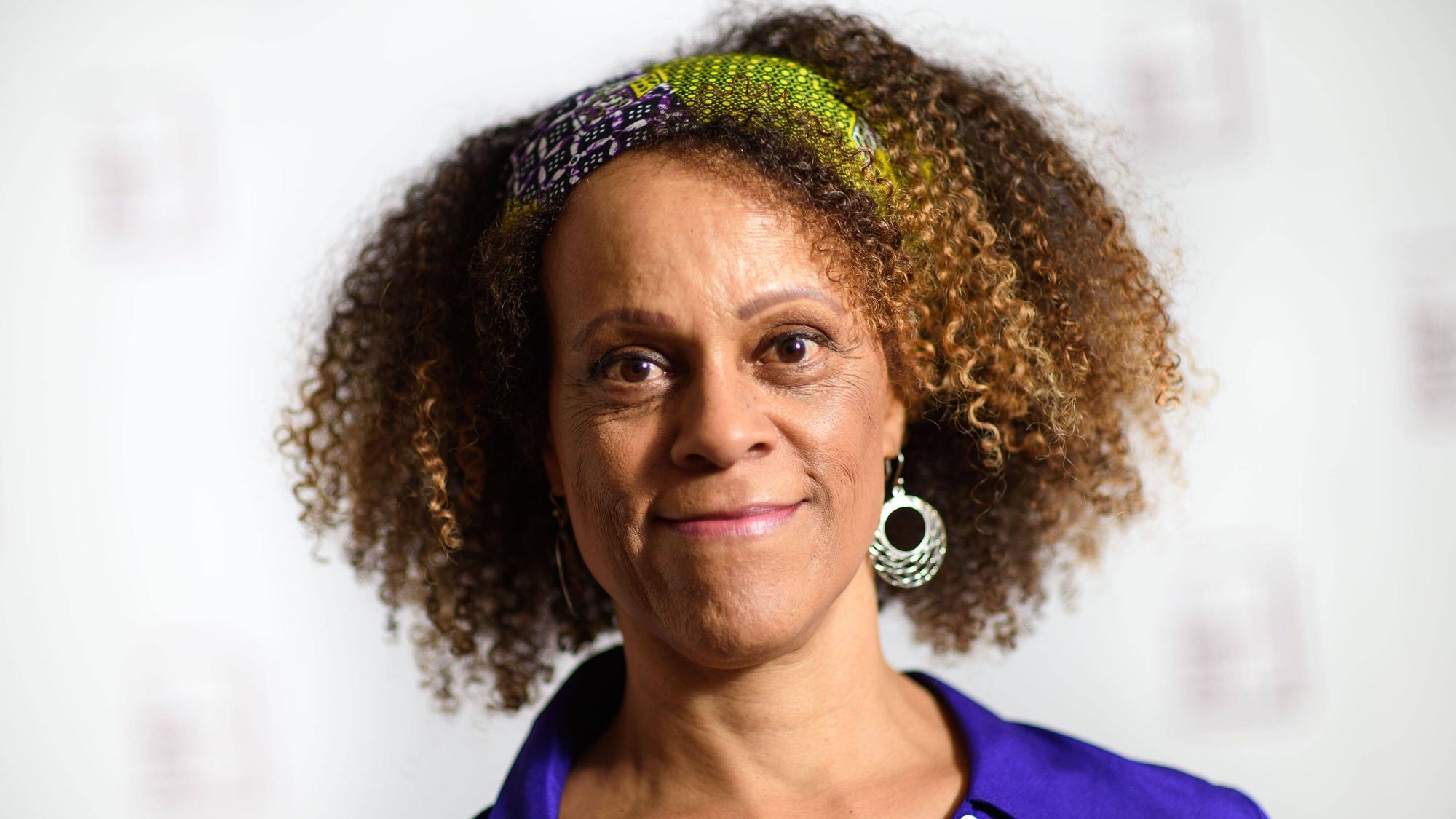 Bernardine Evaristo lächelt in die Kamera. Sie hat eine blaue Bluse an.
