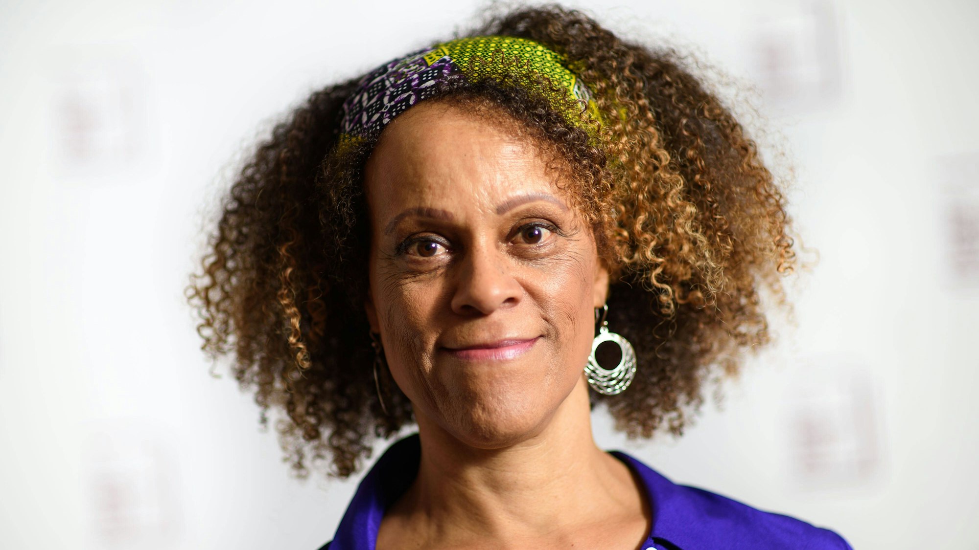 Bernardine Evaristo lächelt in die Kamera. Sie hat eine blaue Bluse an.
