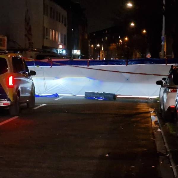 Eine abgesperrte Straße in der Nacht, davor steht ein Polizeiwagen.
