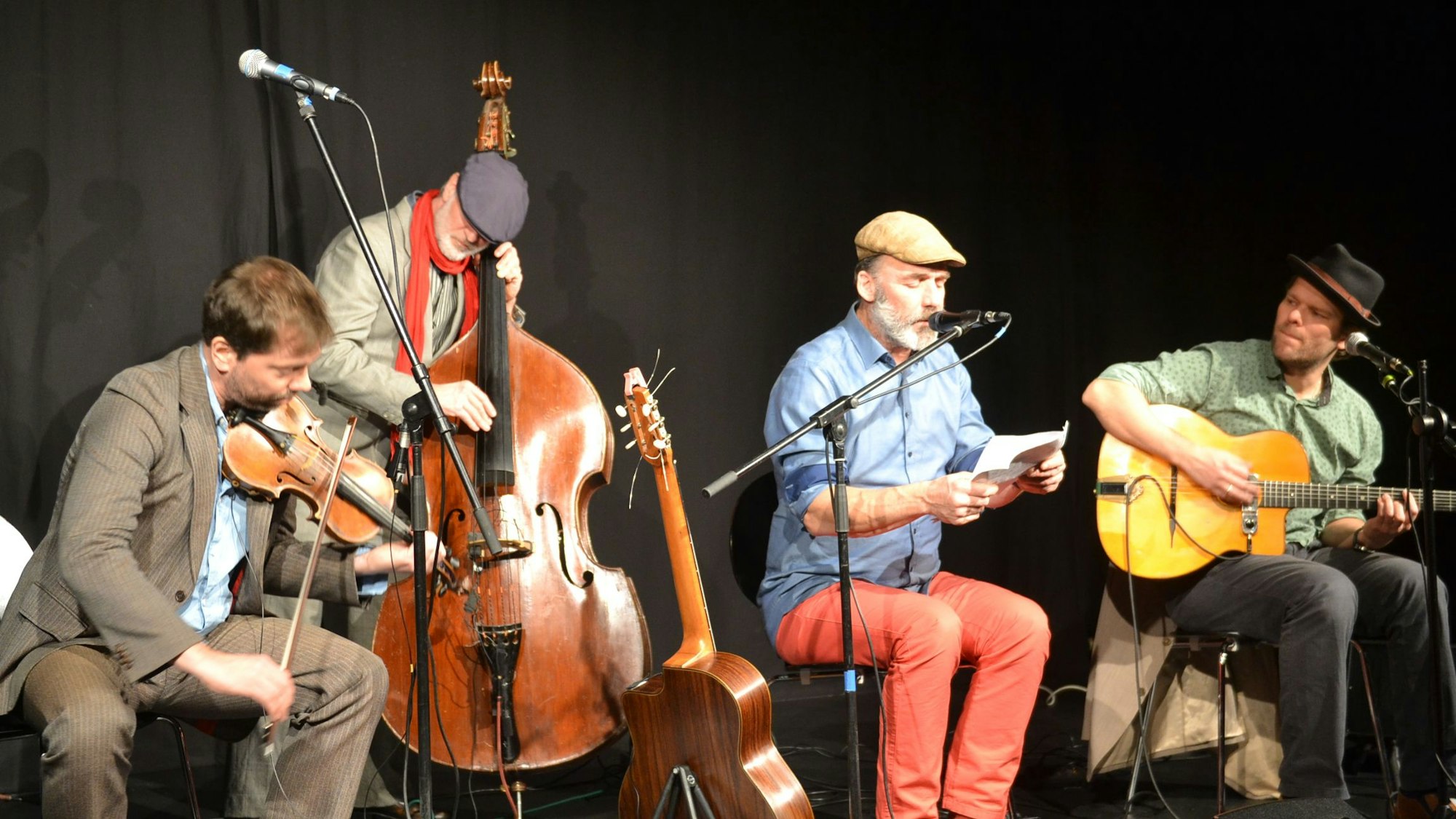 Die vier Musiker des Ensemble Monsieur Pompadour sind mit ihren Instrumenten vor schwarzem Hintergrund auf der Bühne des Theater 1 in Bad Münstereifel zu sehen.