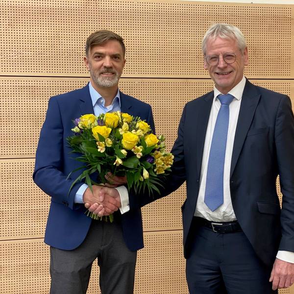 Das Bild zeigt Gerno Böll, frischgewählter Dezernent, wie er von Bürgermeister Dieter Freytag einen Blumenstrauß erhält.