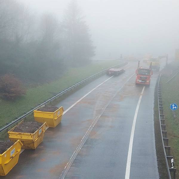 Drei mit Erdreich gefüllte Container stehen auf der B51, die seit einem schweren Unfall am Montag gesperrt ist.