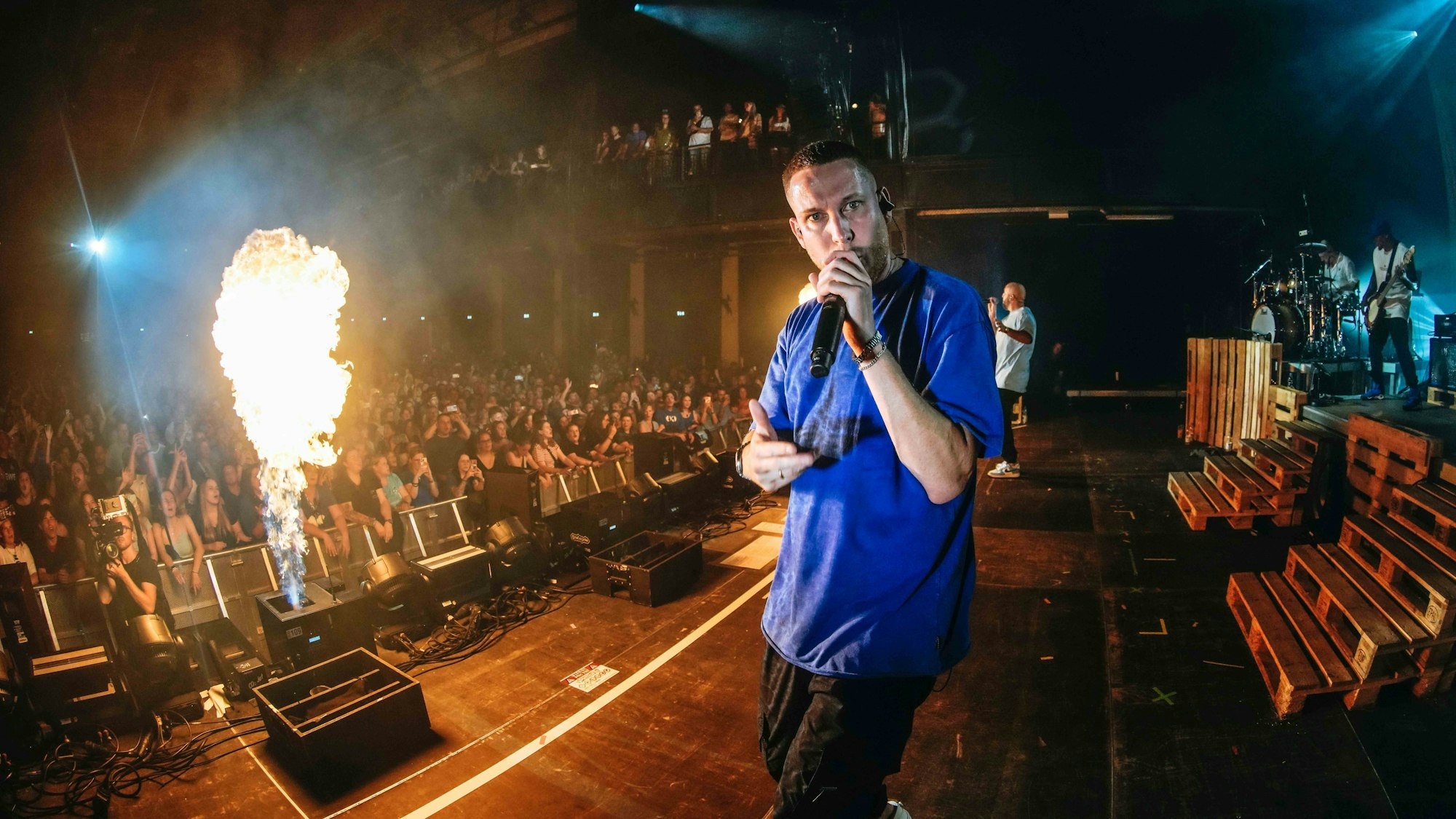 Mo Torres auf der Bühne, neben ihm eine Flamme