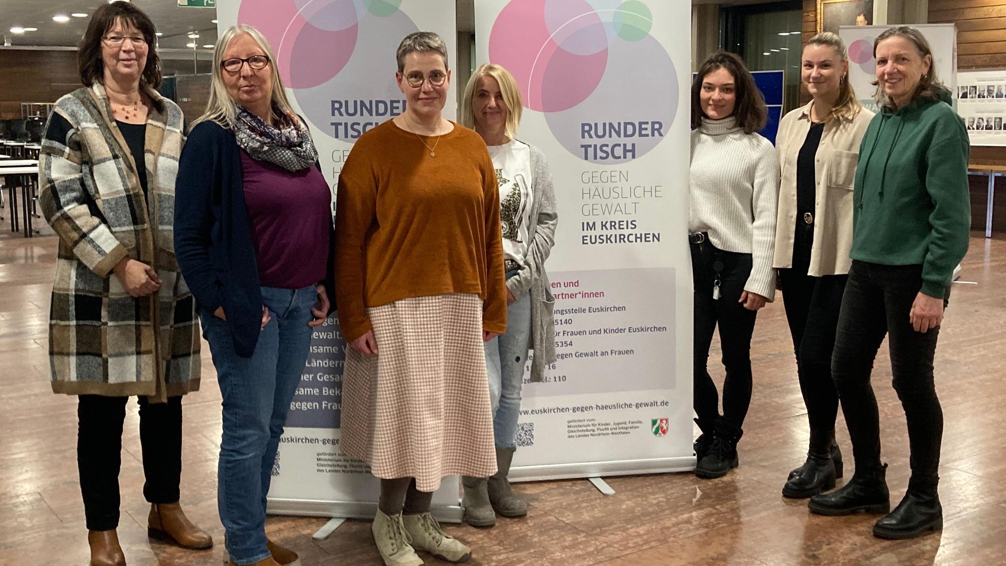 Das Bild zeigt das Orga-Team des Runden Tisches gegen häusliche Gewalt im Foyer des Kreishauses Euskirchen: von links Sabine Weber (Vogelsang IP), Ellen Mende (Frauenberatungsstelle Frauen helfen Frauen), Astrid Günther (Gleichstellungsbeauftragte des Kreises), Eva Winkel (Kreispolizei Euskirchen), Alesha Gashior (Schutzhaus für Frauen), Samira Siepen (Marienhospital Euskirchen), Silvia Alt (Schutzhaus für Frauen).
