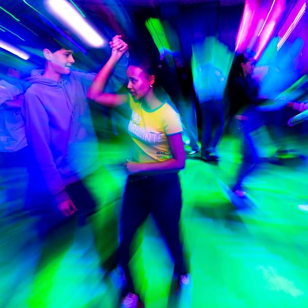 Charlise mit Tanzpartner Anton, eingetaucht in buntes Disco-Licht.