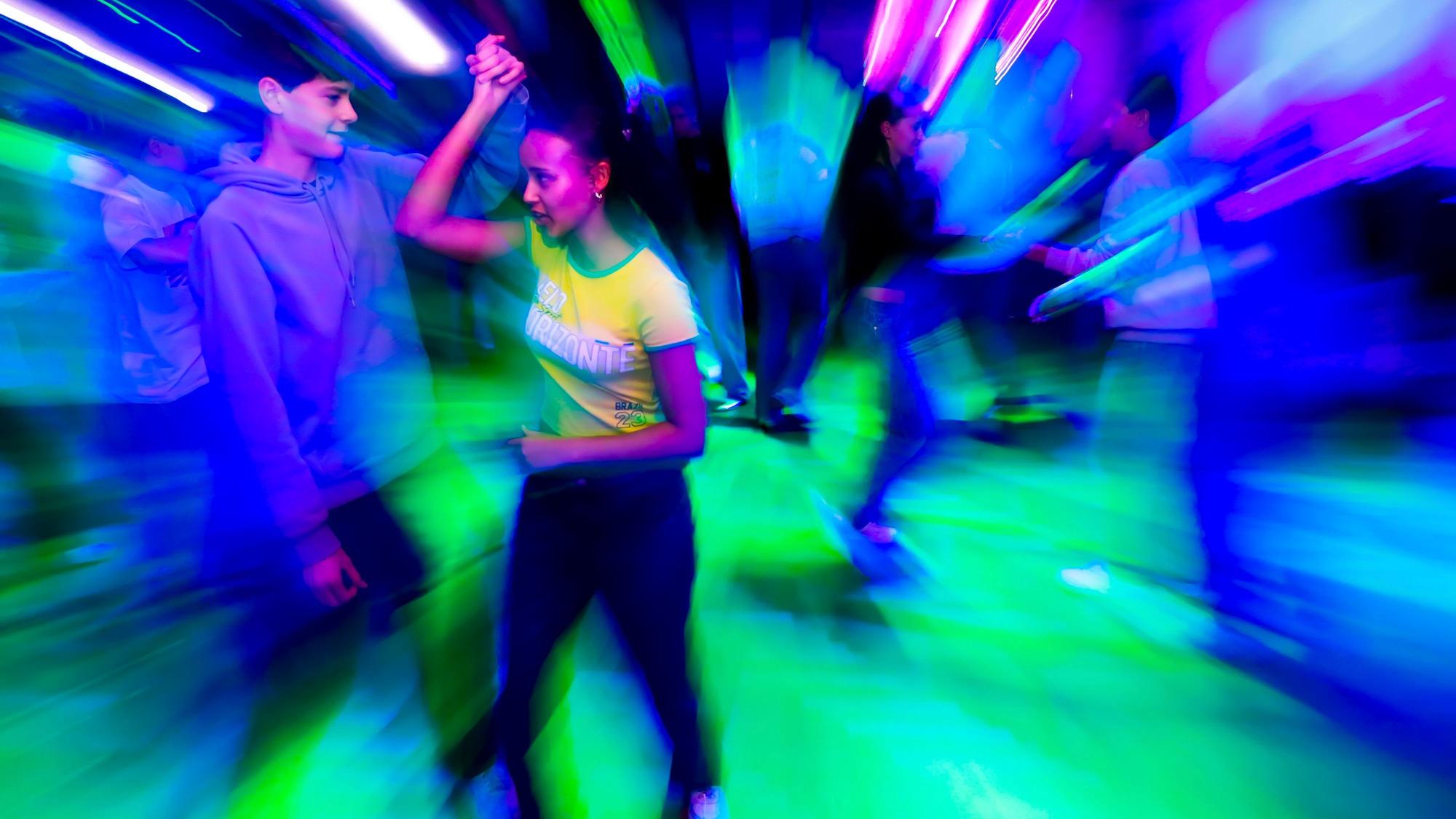 Charlise mit Tanzpartner Anton, eingetaucht in buntes Disco-Licht.