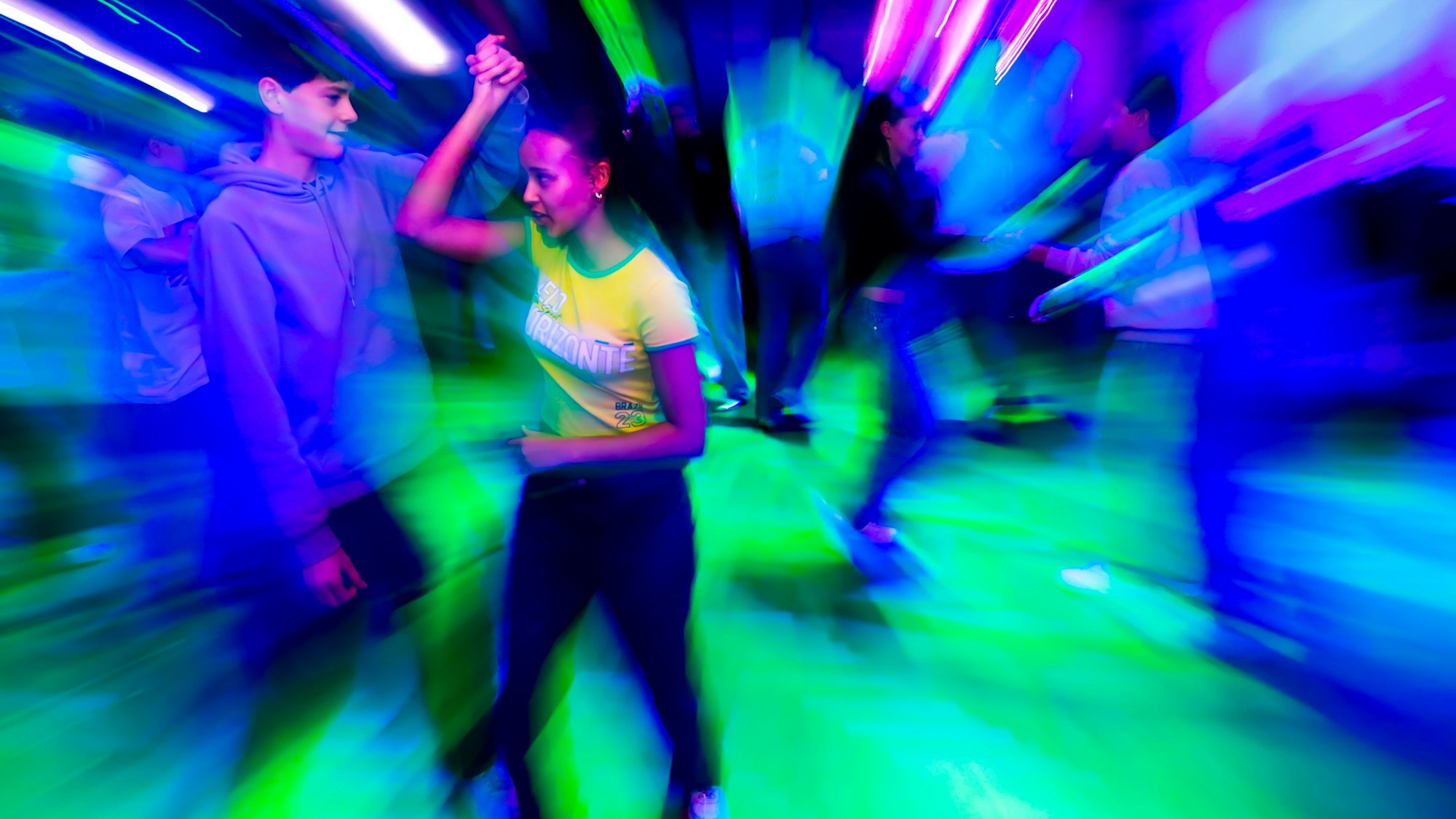 Charlise mit Tanzpartner Anton, eingetaucht in buntes Disco-Licht.