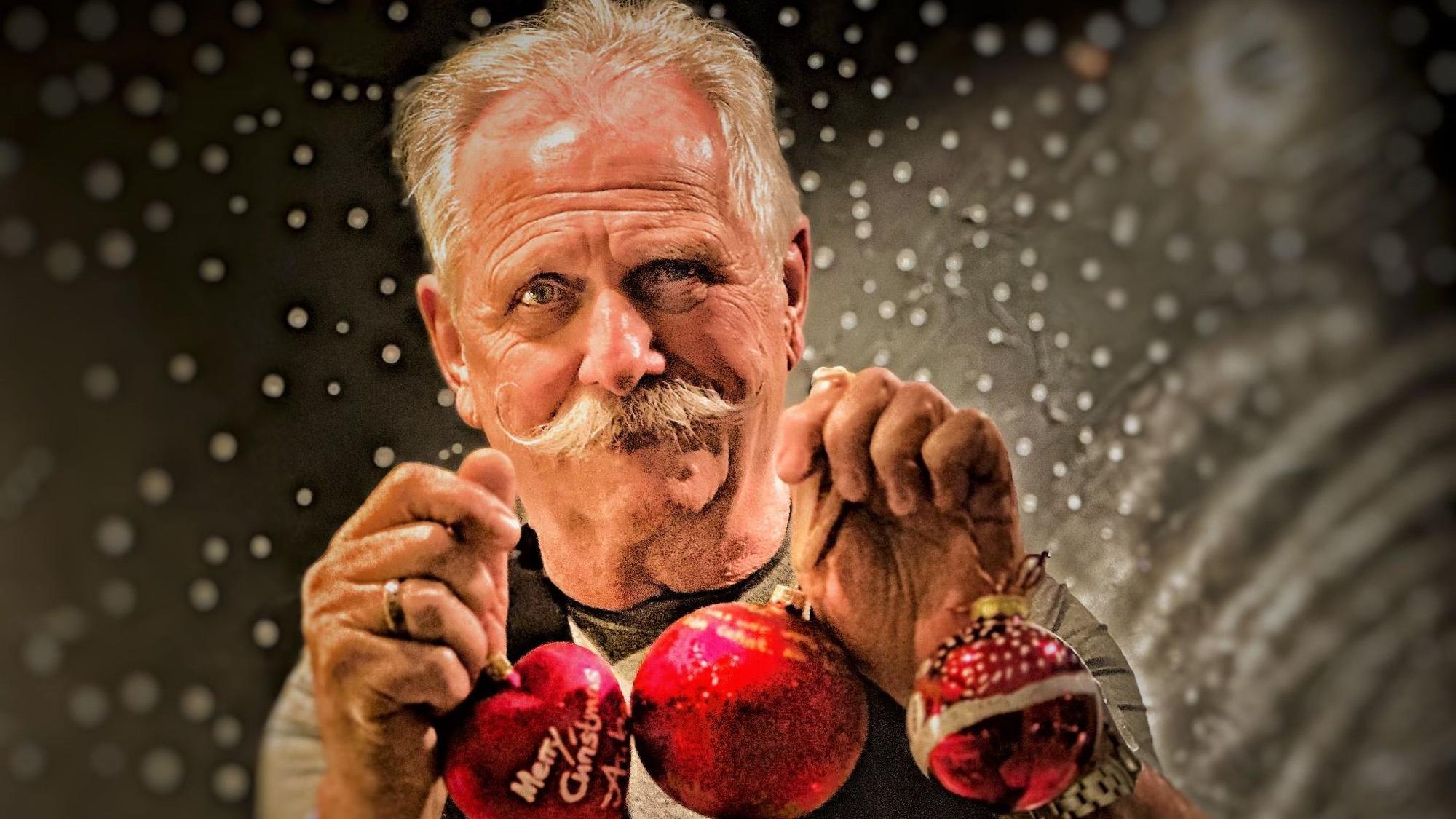 Henning Krautmacher hält selbst gestaltete Weihnachtskugeln.