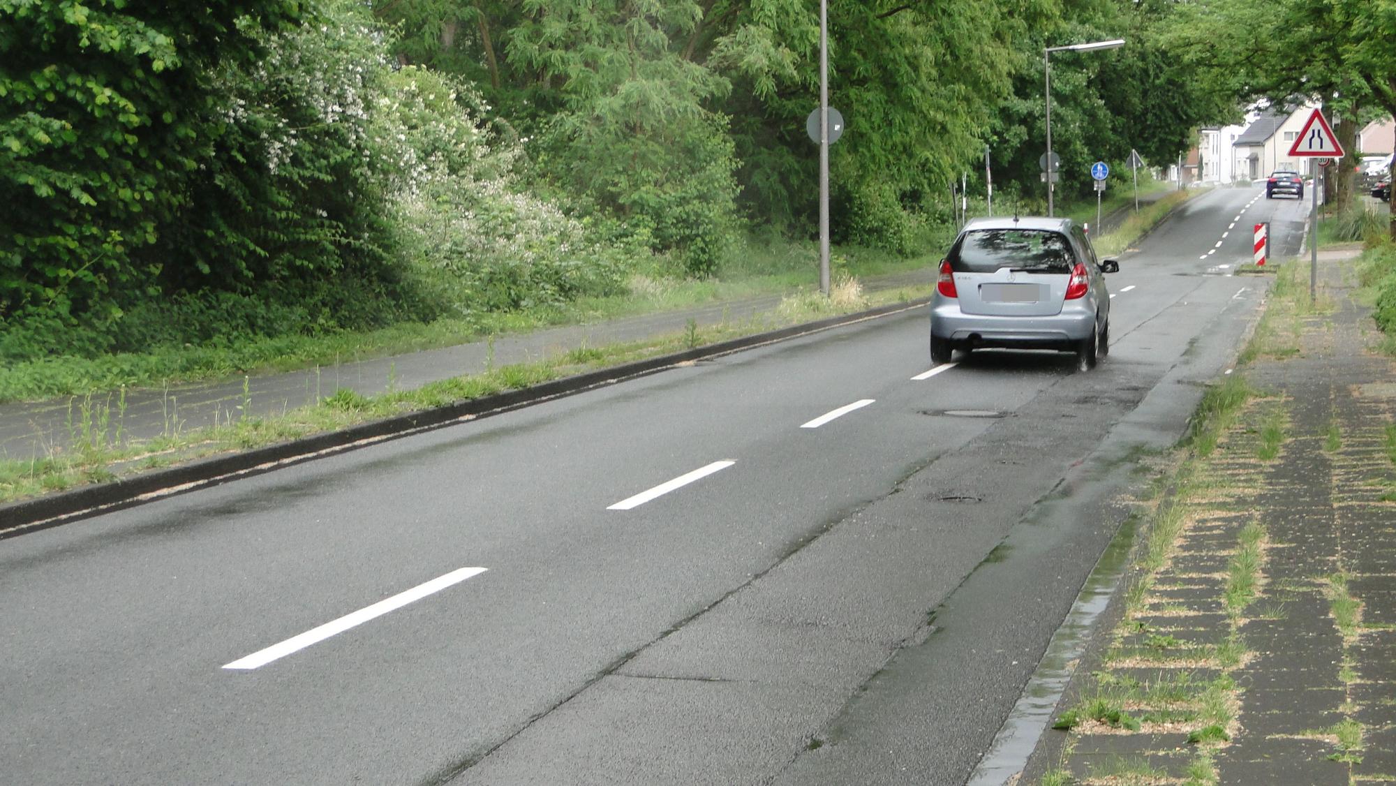 Die Bruchstraße ist stark frequentiert, was am Asphalt seine Spuren hinterlassen Eine Straße mit deutlichen Schäden ist zu sehen.