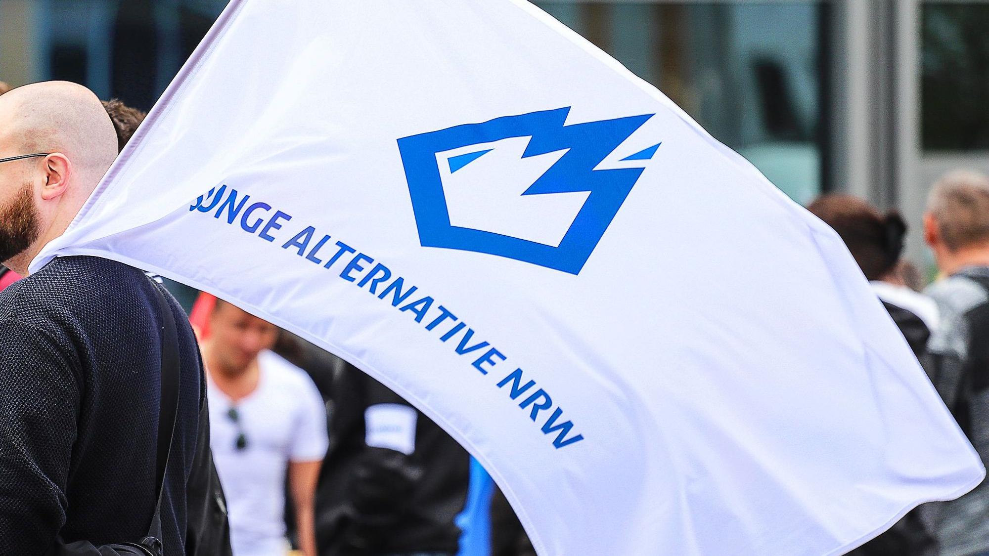 Ein Mitglied der „Jungen Alternative“ (JA), Jugendorganisation der AfD, trägt auf einer Wahlkampfveranstaltung eine Fahne mit dem Logo der Organisation.