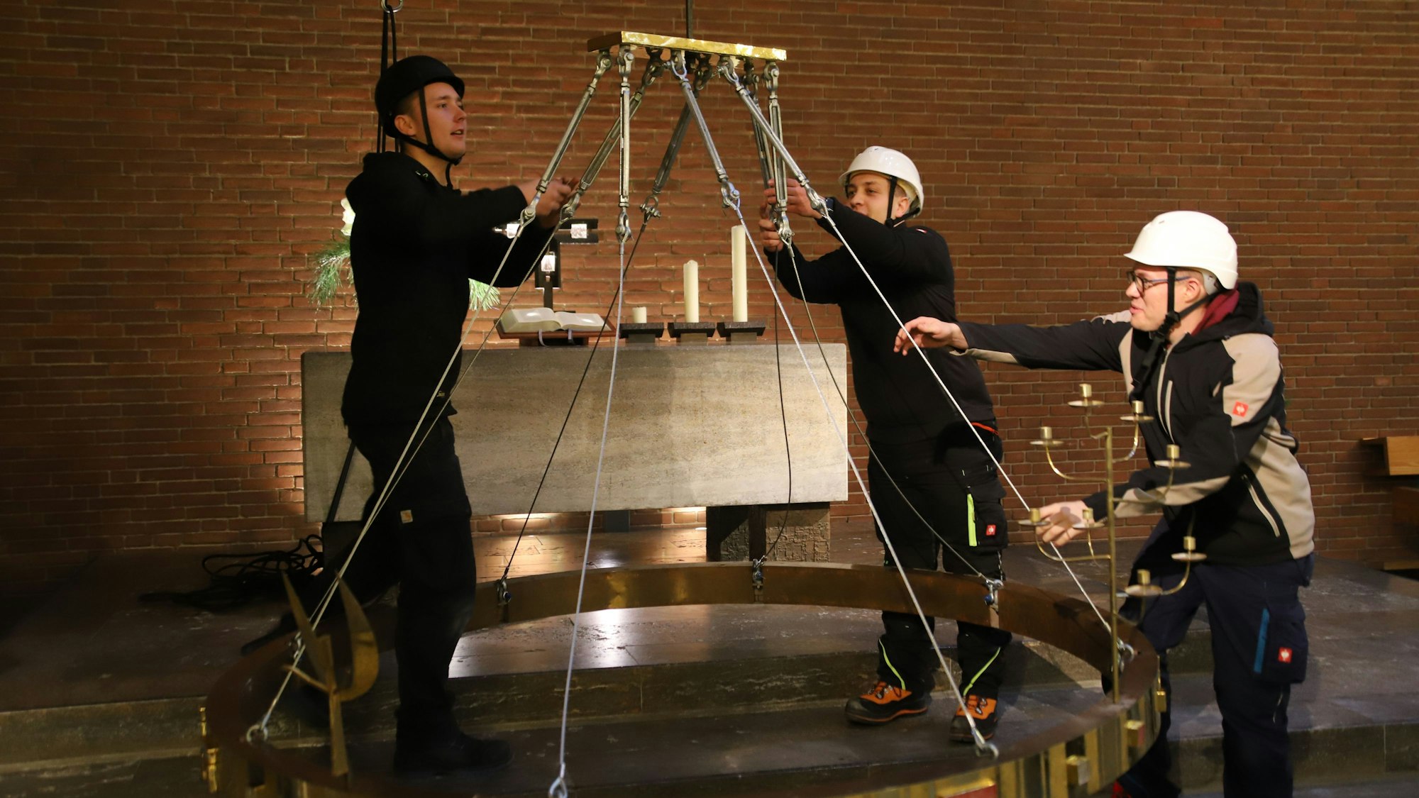 Die Evangelische Kirchengemeinde hat den Jerusalemleuchter nach der Aufarbeitung zurück bekommen, das Technikteam hängte ihn wieder auf. V.l.: Lennart Wipperfürth, Clemens Hoffmann, Lucas Hochgeschurz.