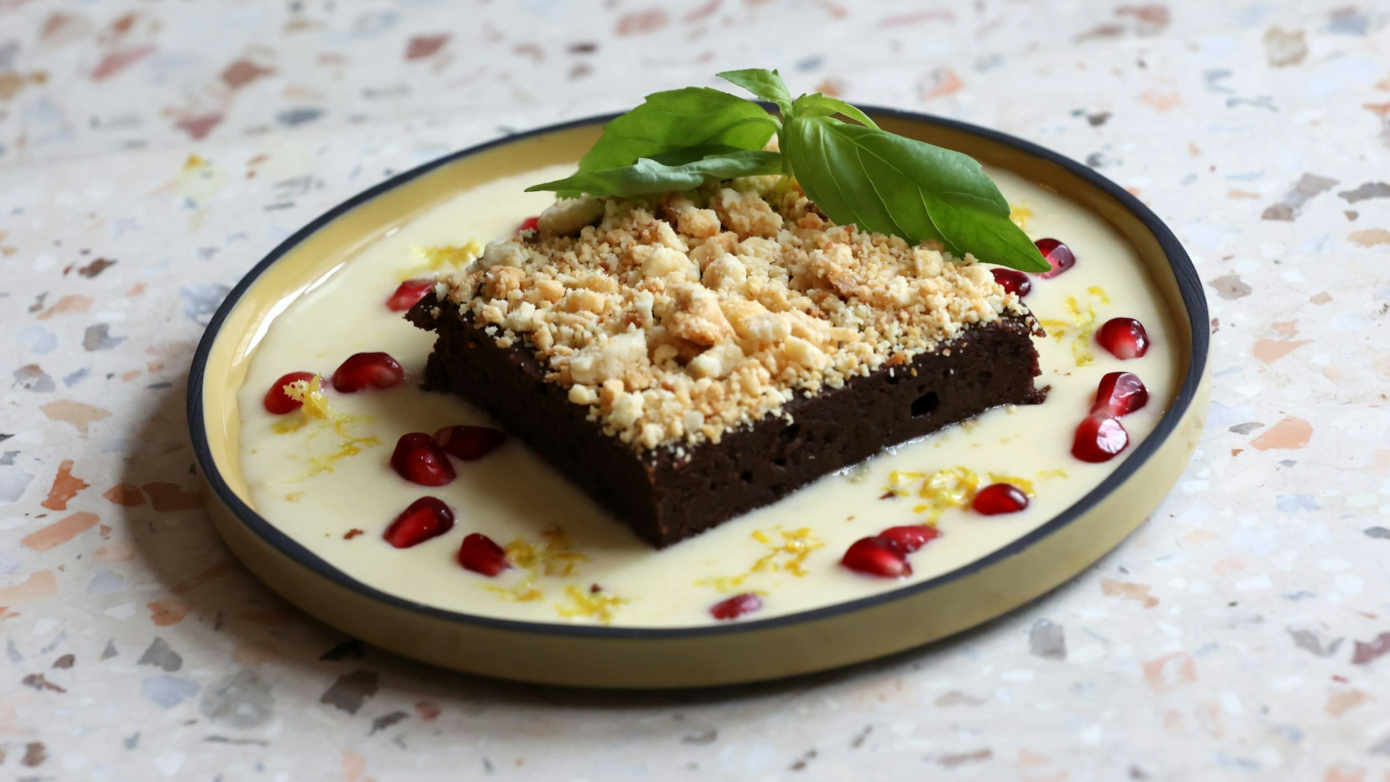 Der Schokobrownie mit Lemon Curd und Granatapfelkernen, karamellisierter weißer Schokolade und Basilikum