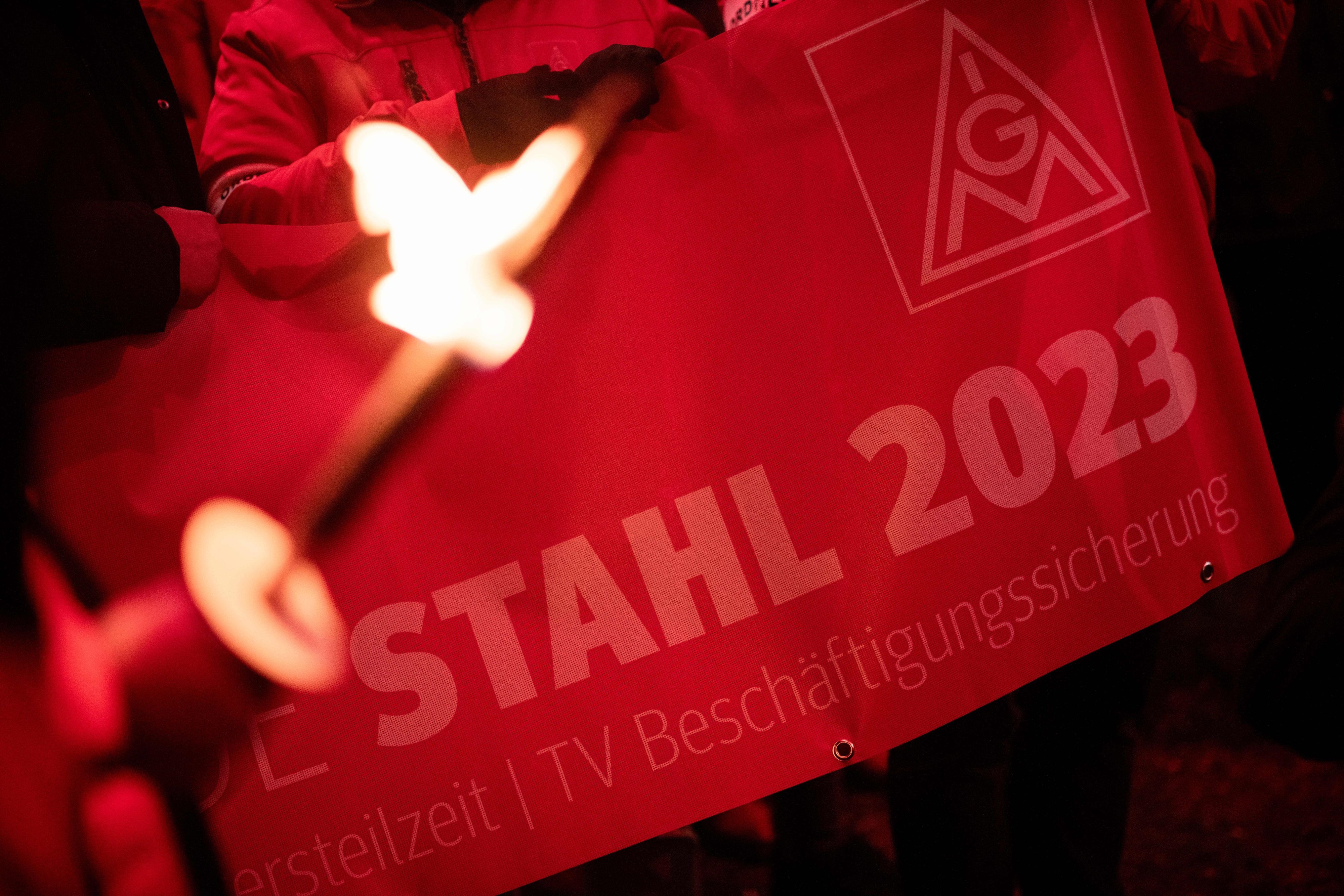 30.11.2023, Nordrhein-Westfalen, Duisburg: Ein Demonstrant hält ein Banner mit der Aufschrift «Stahl 2023» während eines Protests im Zuge des Tarifstreits. Die IG Metall hat im Tarifkonflikt der nordwestdeutschen und ostdeutschen Stahlindustrie nach der vierten Verhandlungsrunde ohne Ergebnis ganztägige Warnstreiks angekündigt. (zu dpa: «Nach ergebnisloser Stahl-Tarifrunde ganztägige Warnstreiks») Foto: Fabian Strauch/dpa +++ dpa-Bildfunk +++