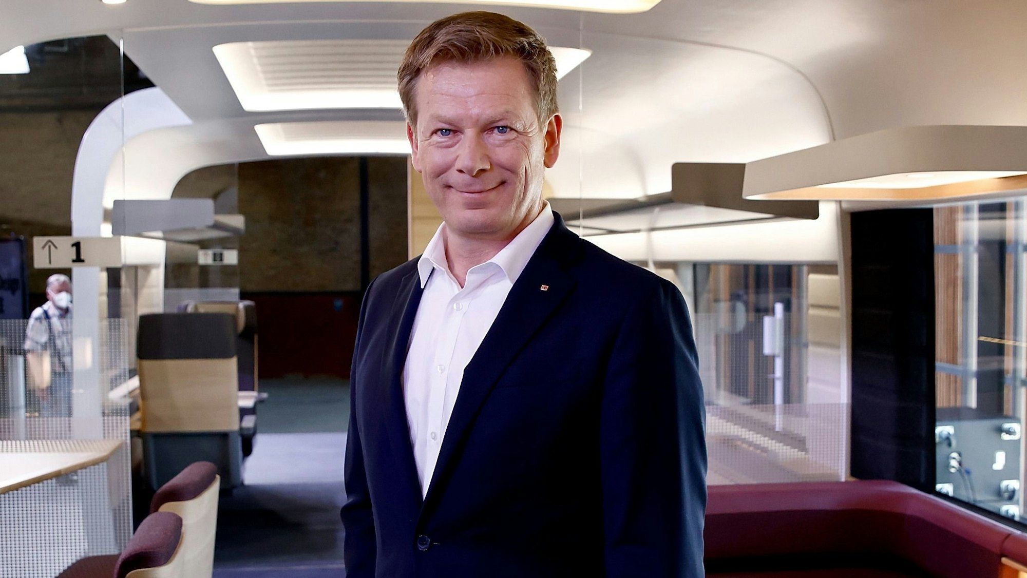 Richard Lutz, Vorstandsvorsitzender der Deutschen Bahn, steht bei der Präsentation des neuen Designs im ICE in einem Modellwagen.