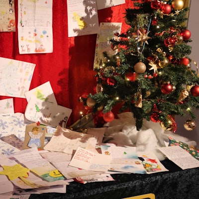 Ein weihnachtlich dekorierter Tisch voller Wunschzettel.