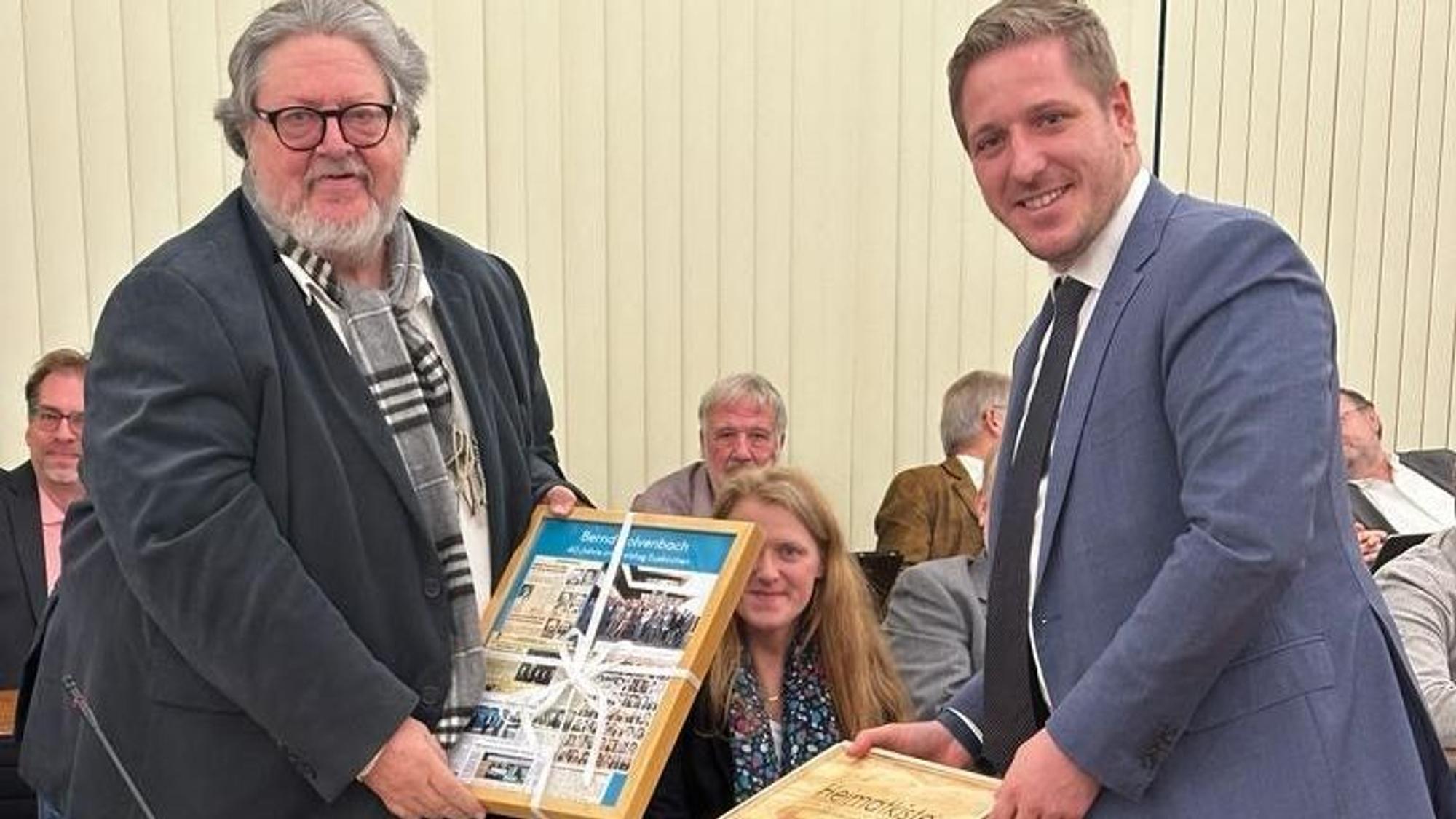 Das Bild zeigt Markus Ramers, der Bernd Kolvenbach ein Geschenk überreicht.