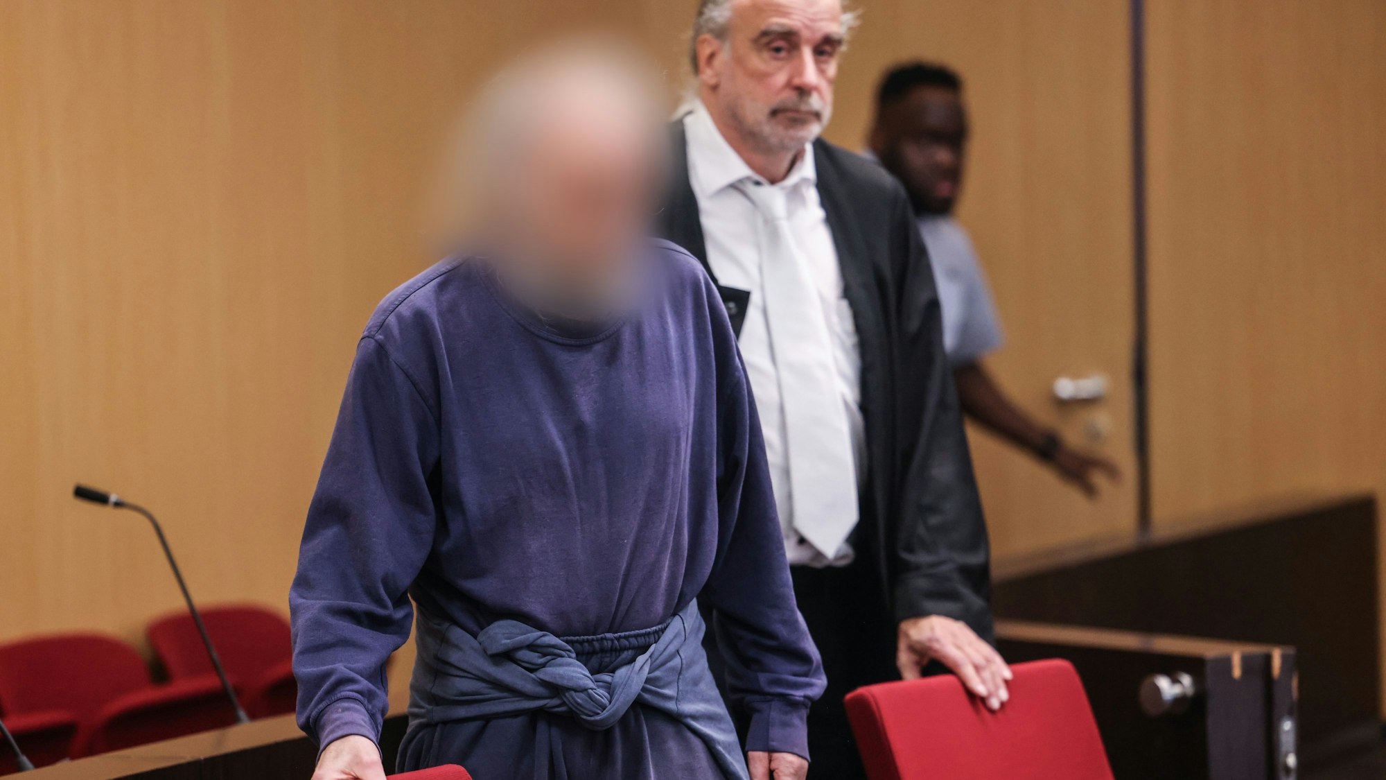 Der Angeklagte kommt neben seinem Anwalt in den Gerichtssaal.