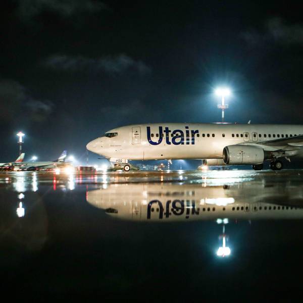 Eine Boeing 737 der russischen Fluggesellschaft UTair steht unter einem großen Scheinwerfer auf einem Rollfeld. Die Warnleuchte an den Tragflächen leuchtet. (Symbolbild)