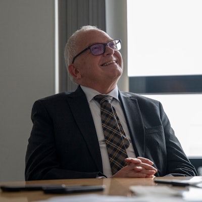 Johannes Hermanns sitzt an einem Besprechungstisch.