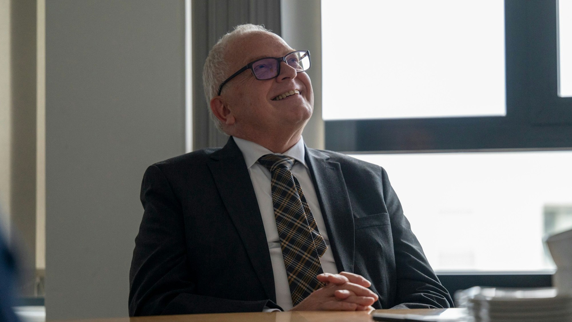 Johannes Hermanns sitzt an einem Besprechungstisch.