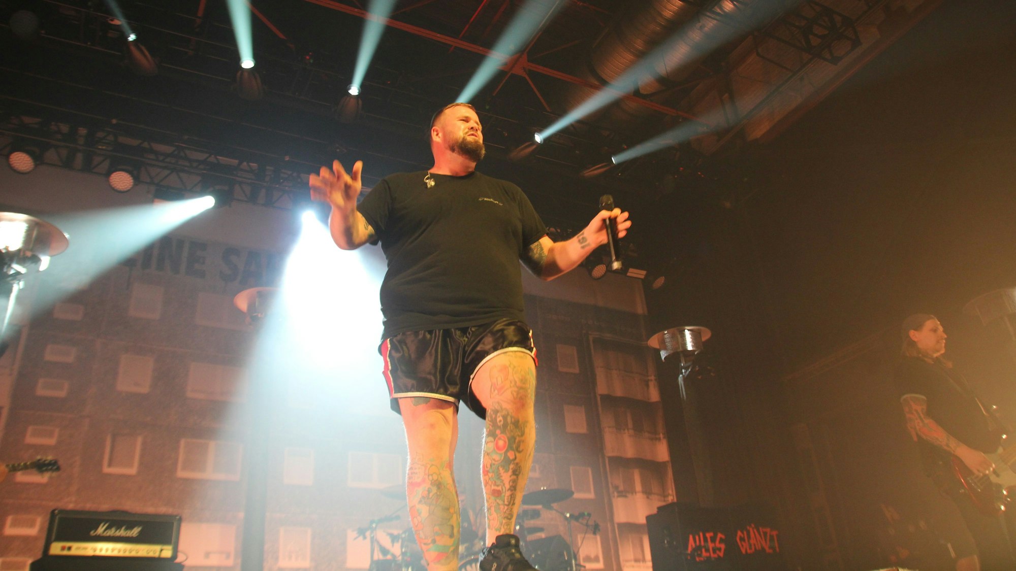 Sänger Jan Gorkow steht am Bühnenrand, über seinem Kopf leuchten viele Scheinwerfer.