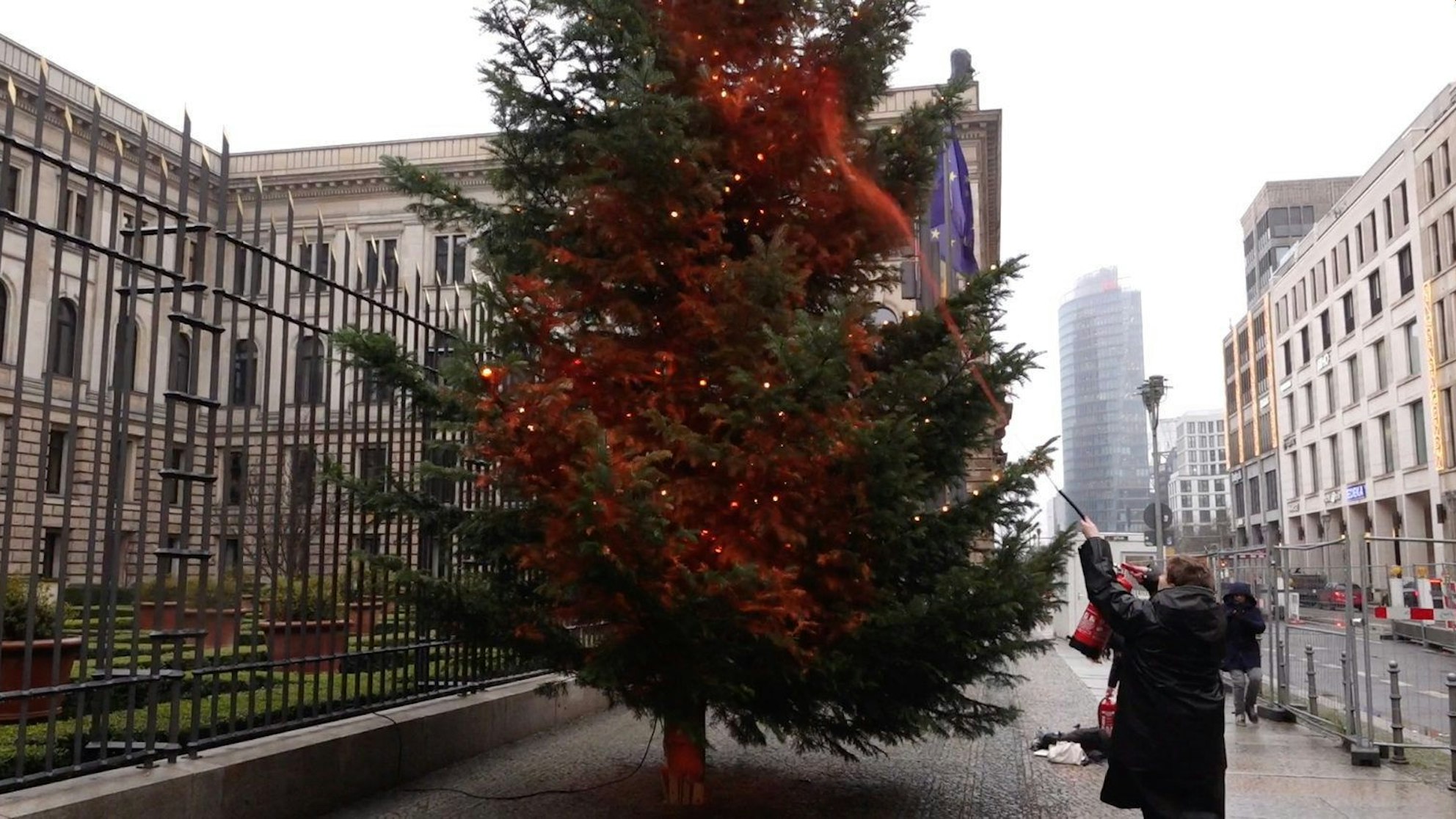 Ein Mitglied der Klimaschutzgruppe ‚Letzte Generation‘ besprüht einen Weihnachtsbaum in Berlin mit Farbe.