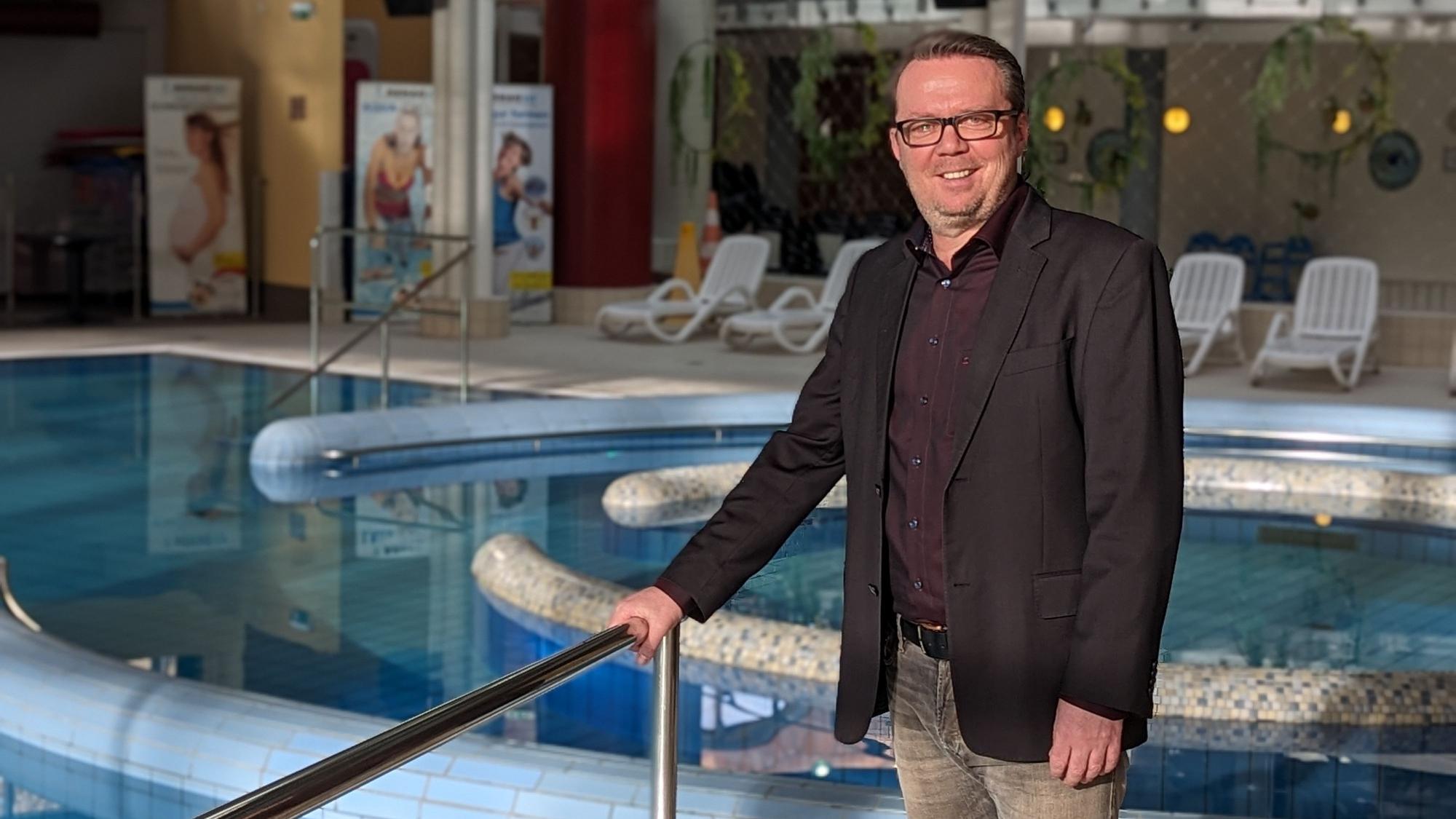 Ein Mann im Anzug vor dem Erlebnisbecken im Familienbad De Bütt in Hürth.