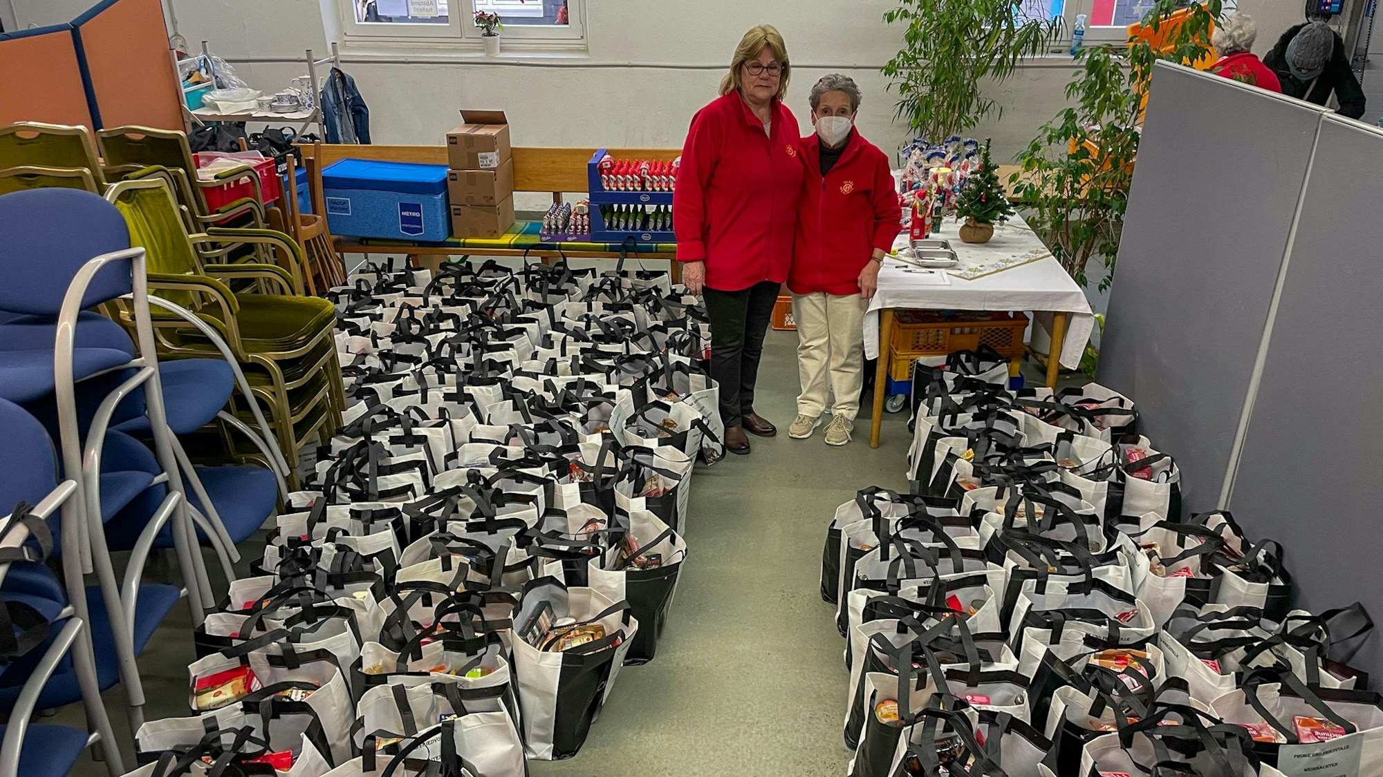 Zwei Frauen stehen zwischen schwarz-weißen Tüten.