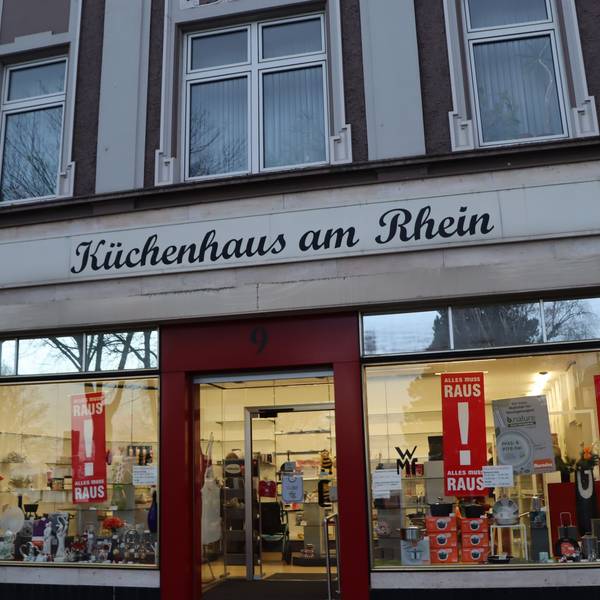 Eine Ladenzeile mit zwei großen Schaufenstern in einem historischen Gebäude.