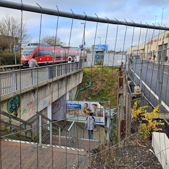 Eine Treppe, die zu einem Bahnsteig führt, ist teils von einem Bauzaun umgeben.